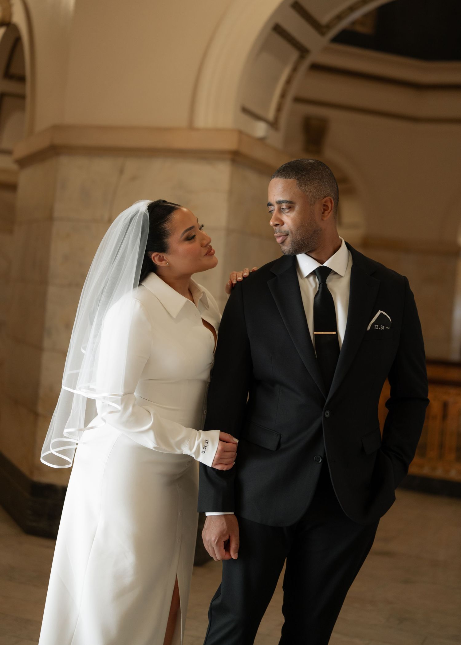 A couple shares romantic moments in an elegant indoor venue during their wedding celebration.