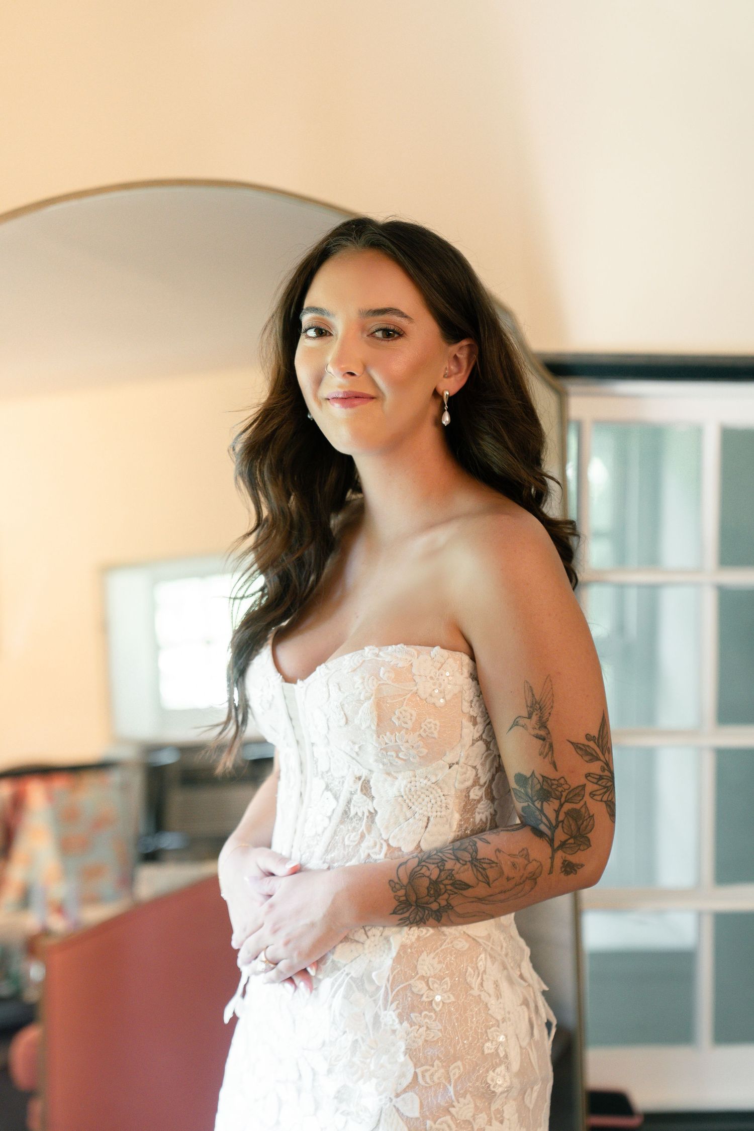 Close-up shots of a white lace wedding dress with intricate details and tattoo artwork.