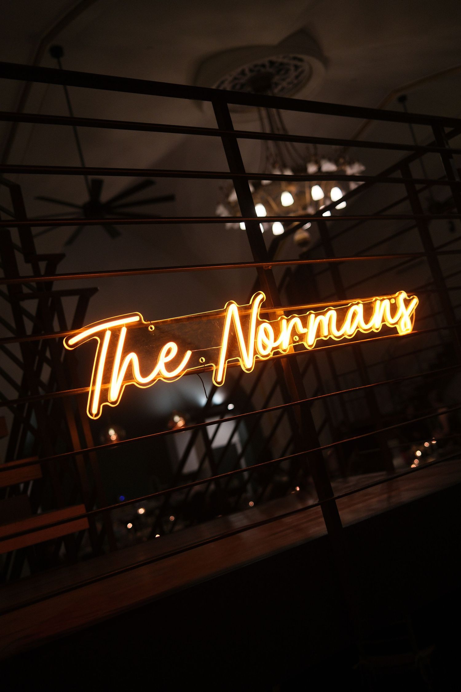 An illuminated neon sign glows in orange against a dark background at an event venue.