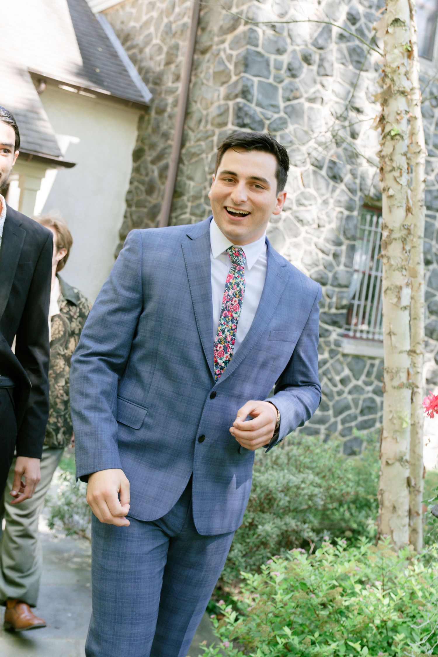 Outdoor wedding photos showing a person in a blue checkered suit smiling in a garden setting.