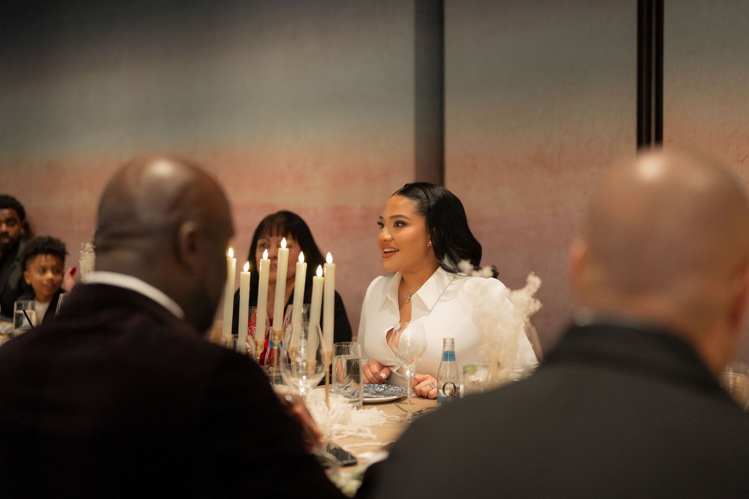 An elegant dinner reception with candlelit table settings and warm ambient lighting.