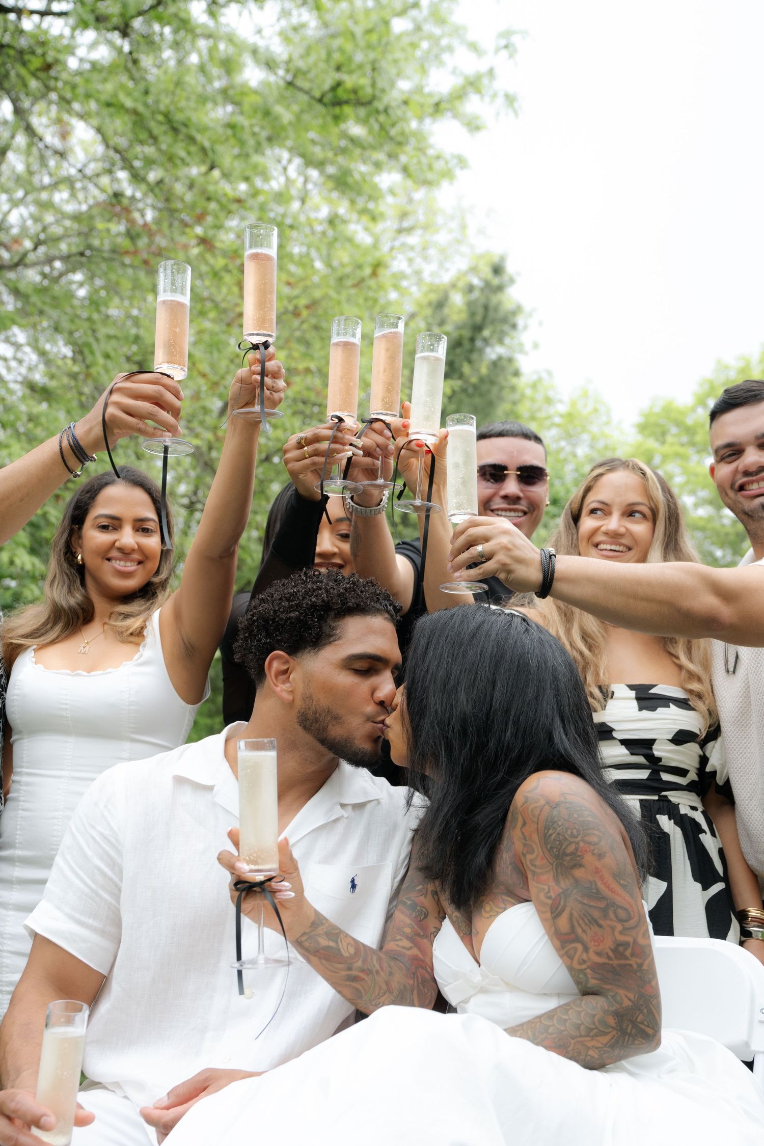 Group toasting with champagne glasses at an outdoor celebration.
