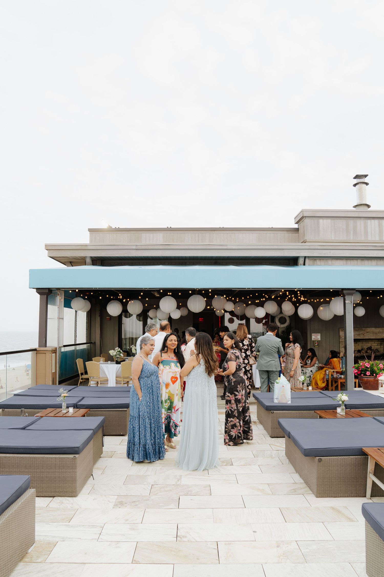 Rooftop venue decorated with balloons and outdoor seating overlooking the ocean.