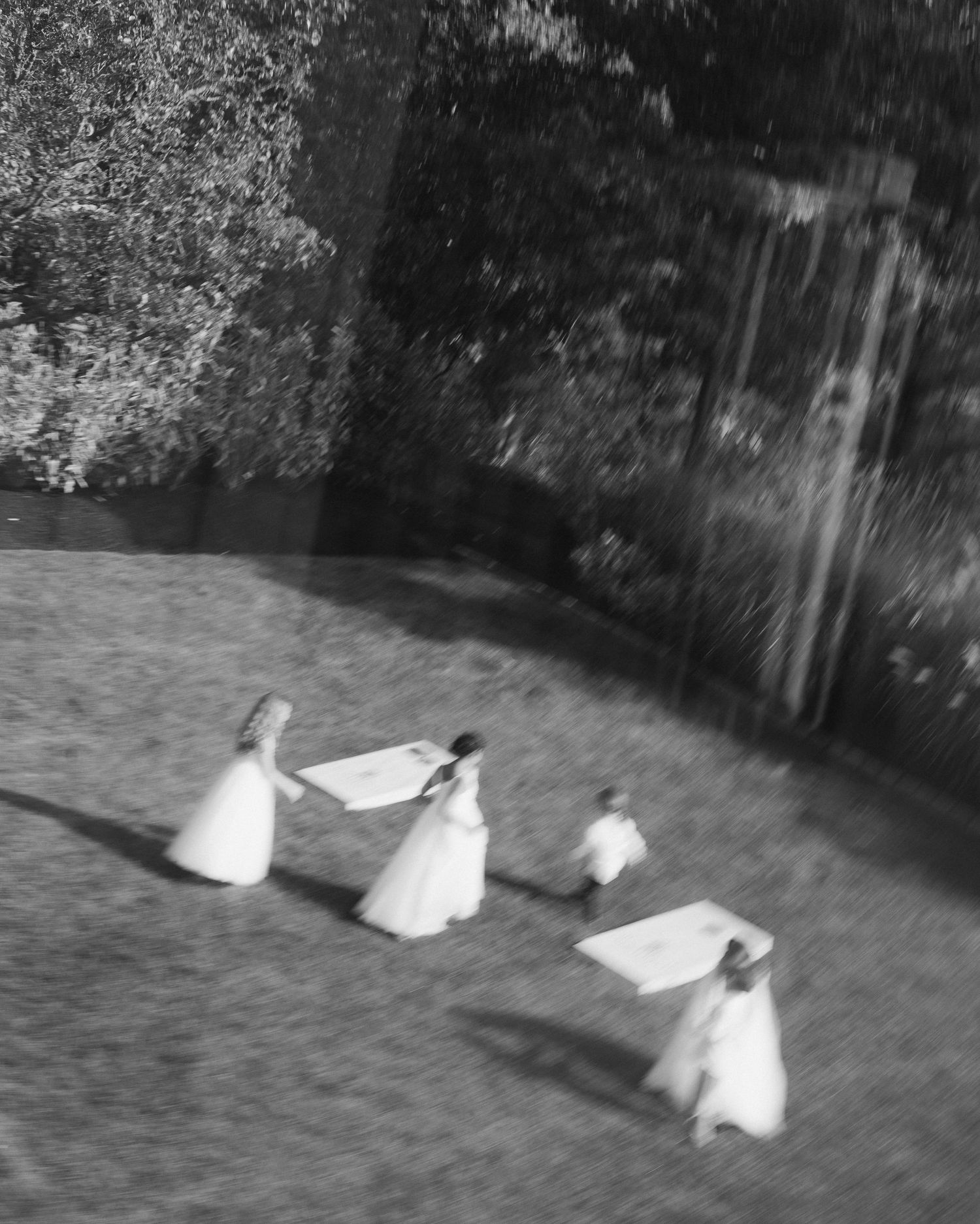 A sequence of black and white images showing someone in white clothing rolling across a grassy lawn.