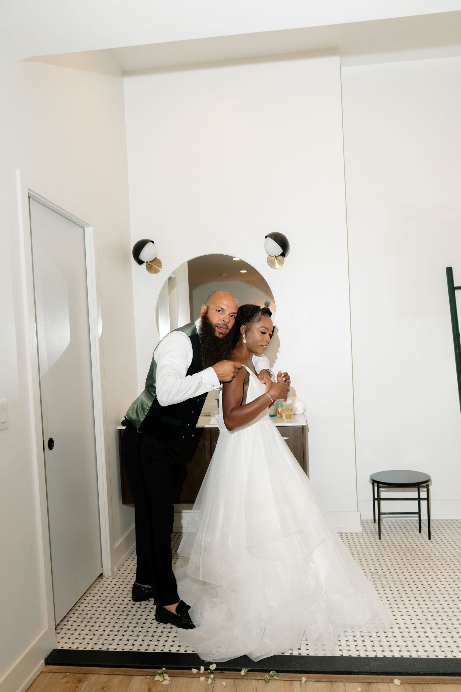 Playful wedding couple poses for fun photos in bright indoor setting.