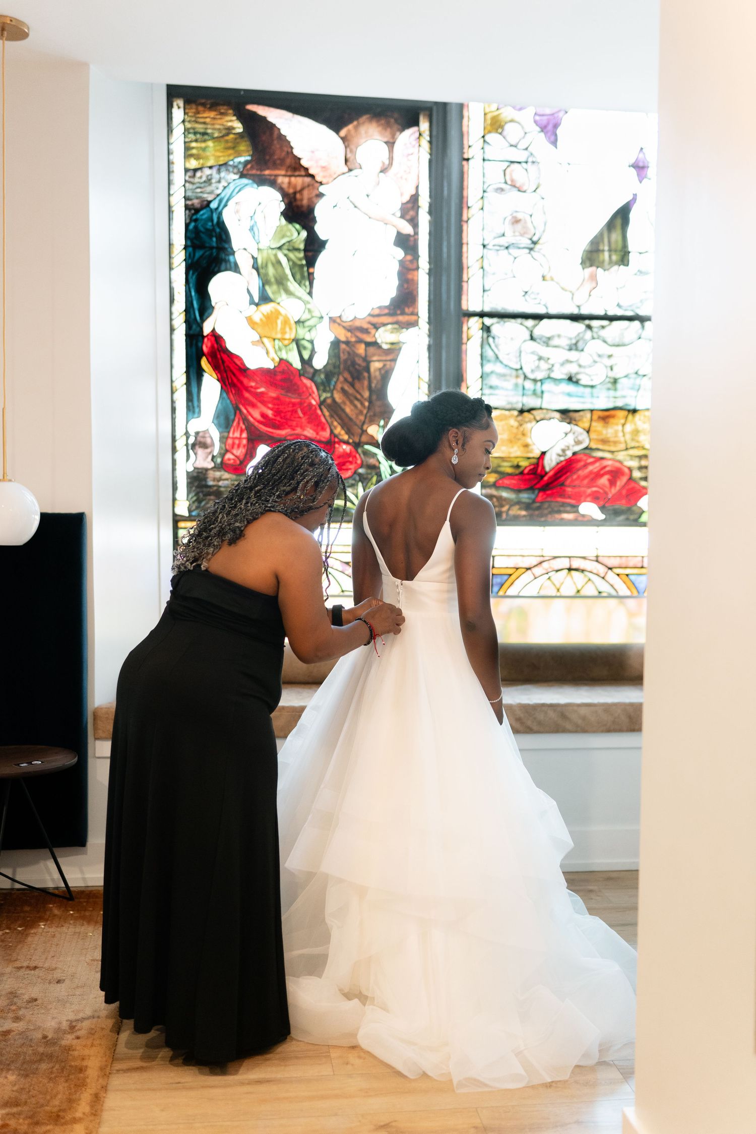 Wedding dress preparation scene with attendants helping the bride get ready.