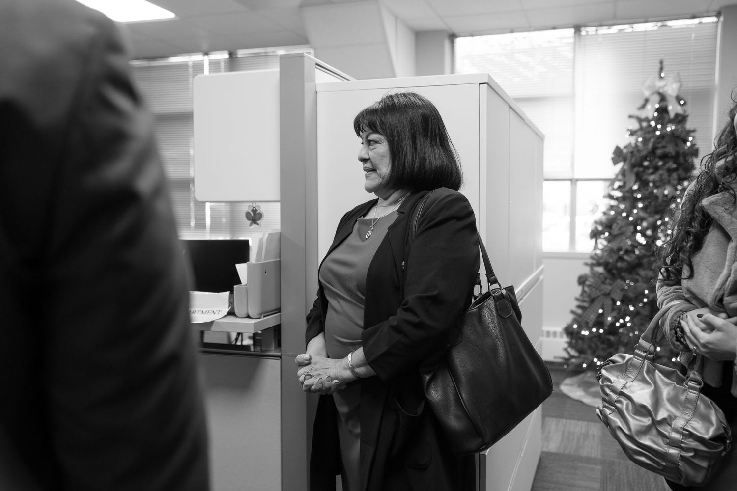 Black and white candid shots in an office setting with holiday decorations.