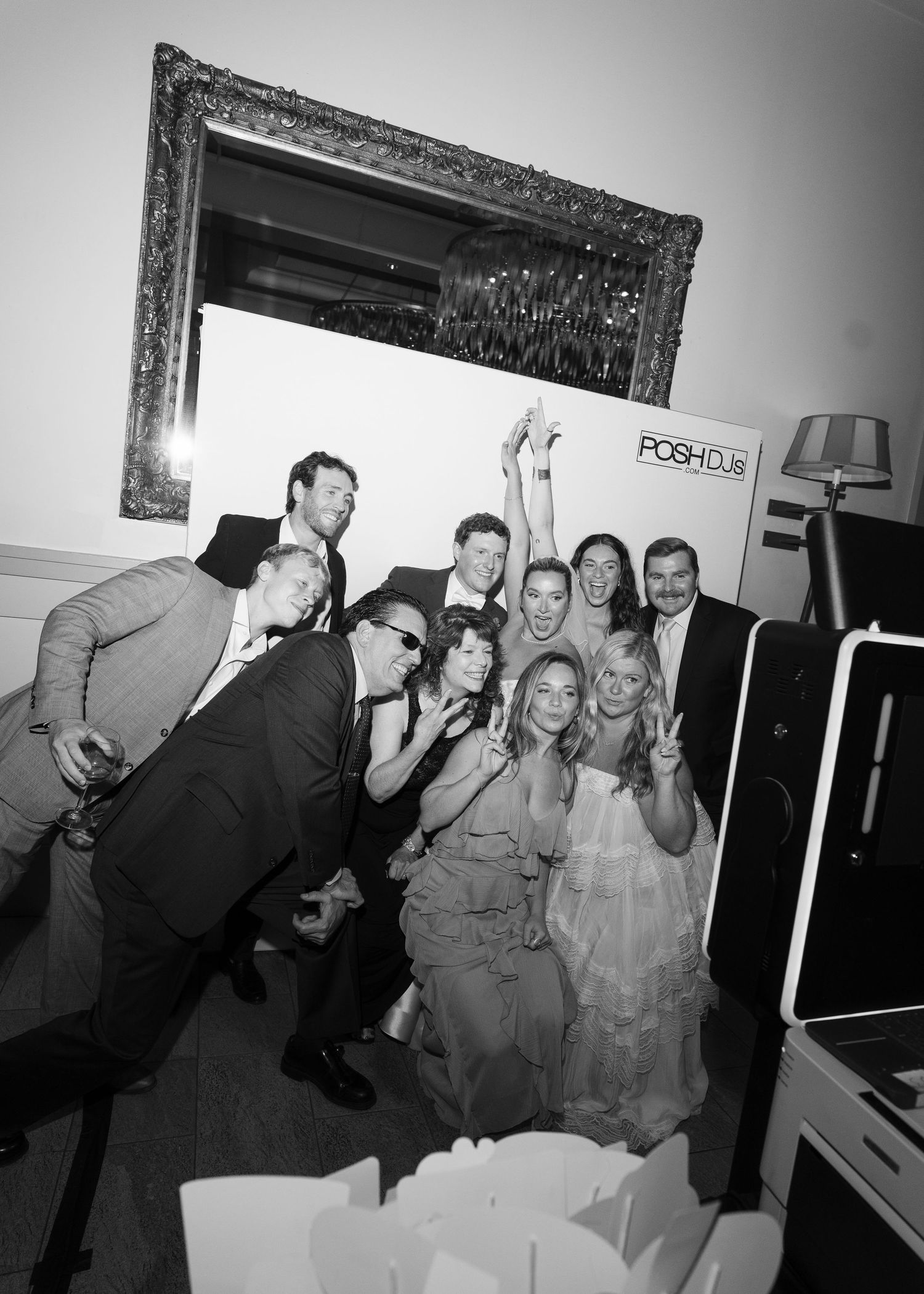 Black and white photo of a cheerful group posing together at a party near a POSH DJS booth.