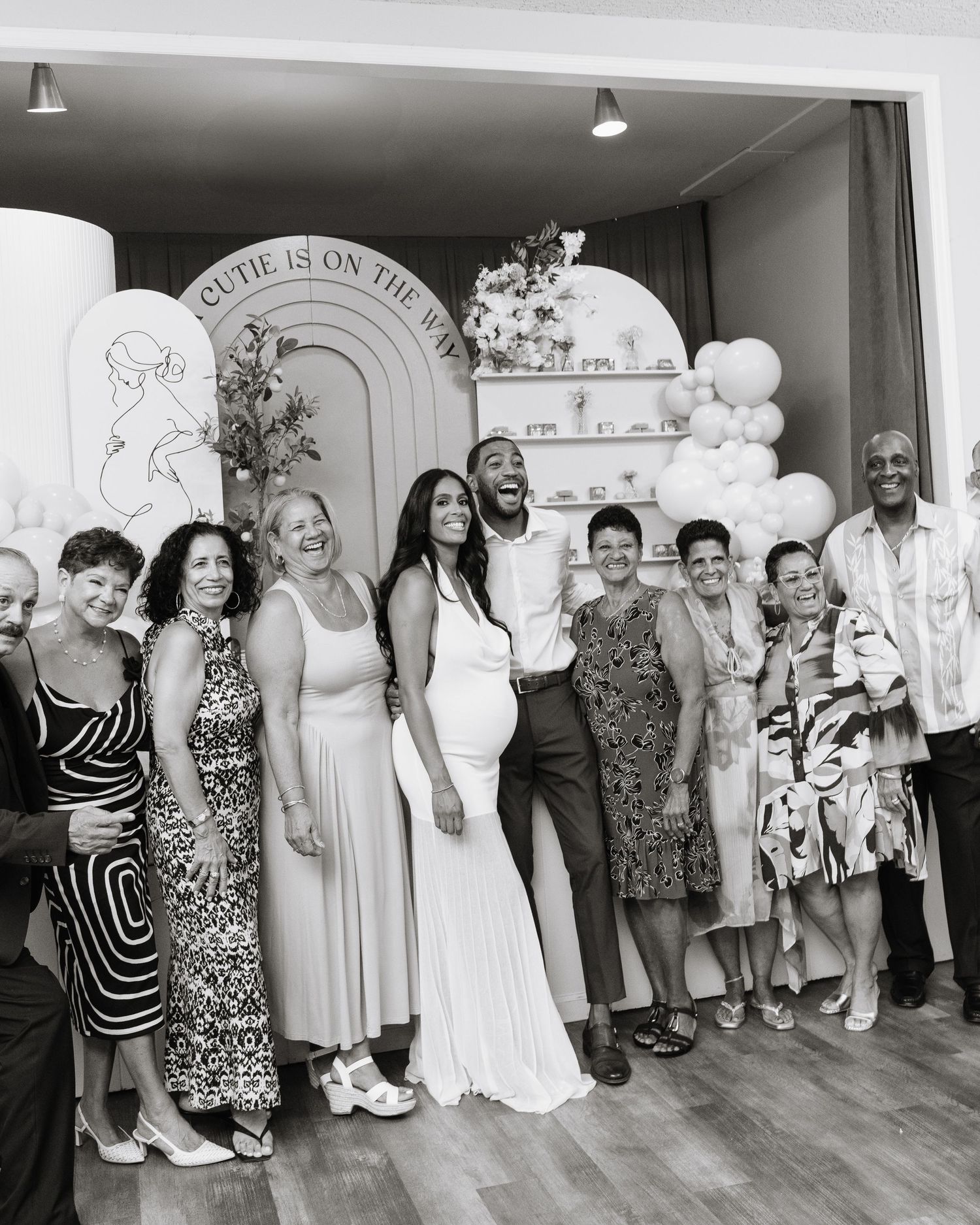 Large group poses together against white wall at formal event in black and white photo.