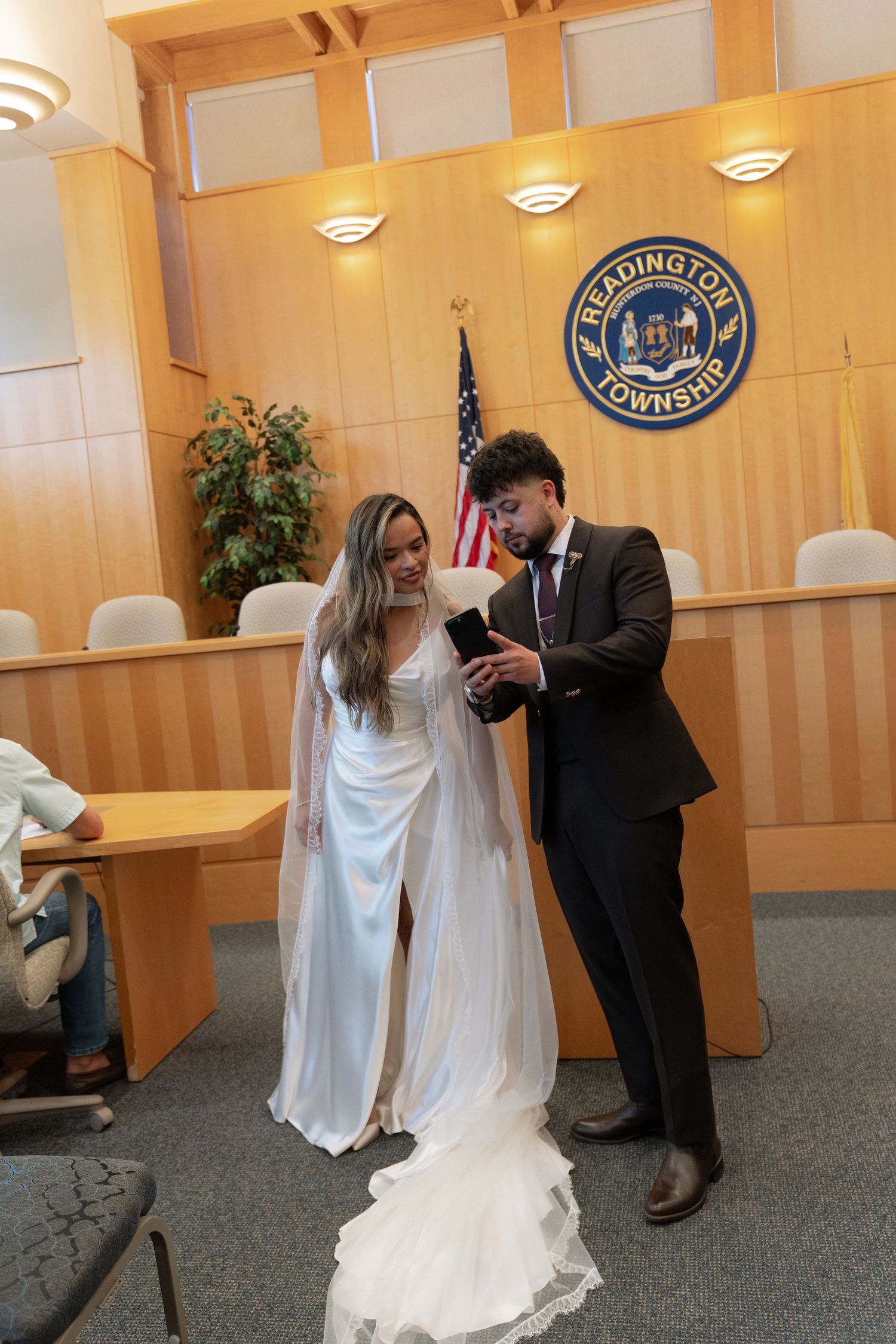 Bride and groom exchanging rings inside Readington Township municipal building ceremony room.
