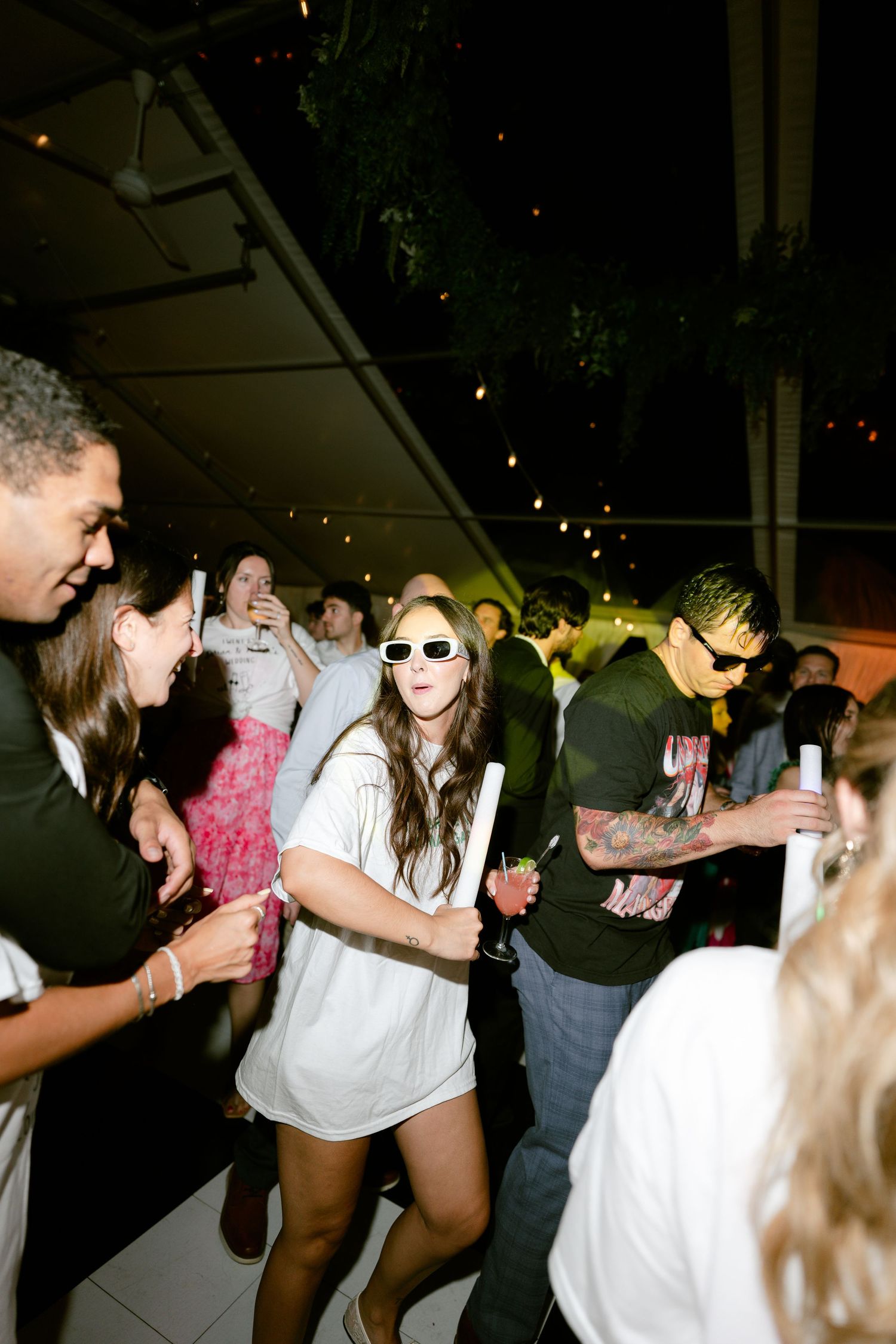 Lively dance floor scene at a nighttime wedding reception.