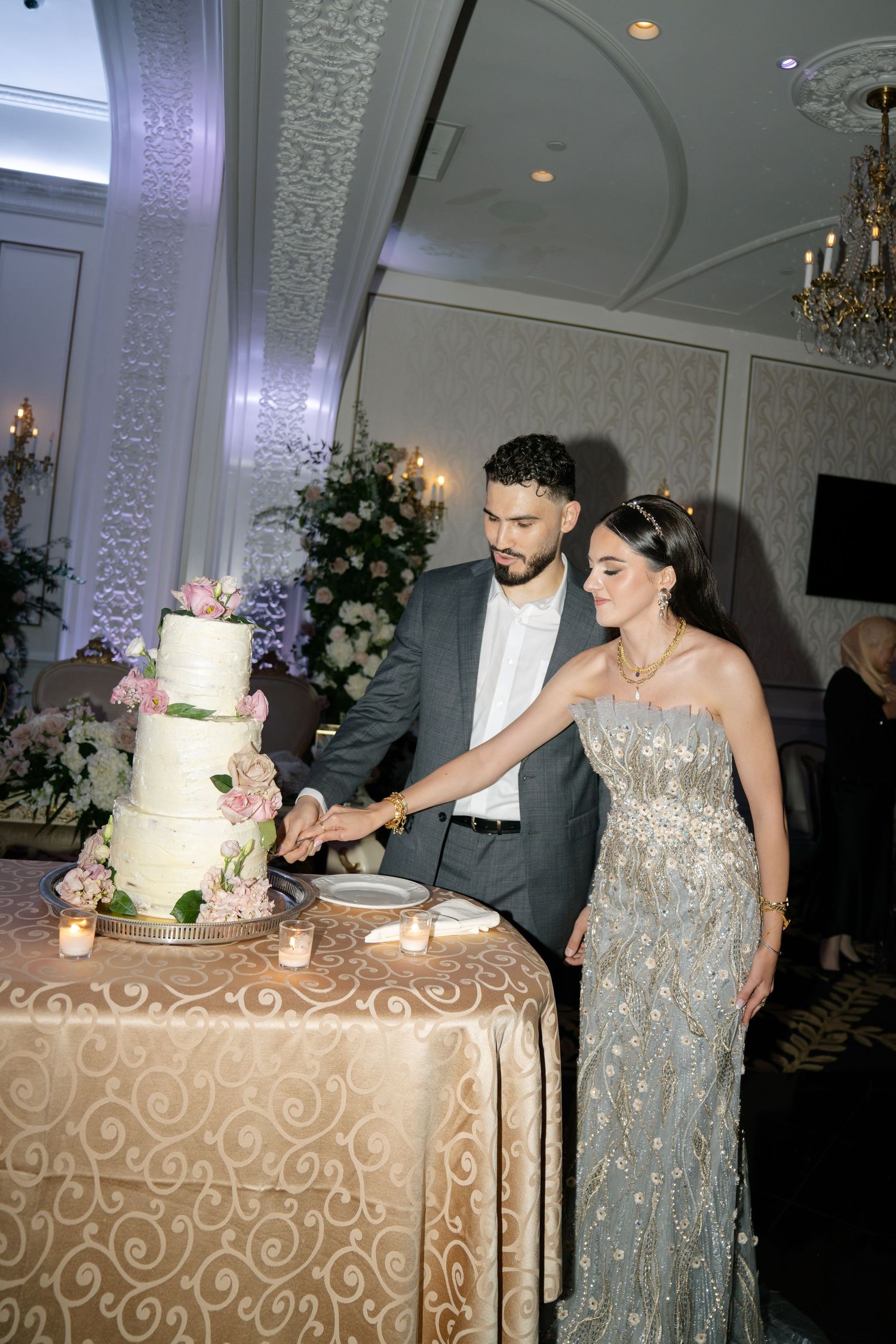 Couple cutting their elegant white wedding cake at their reception.