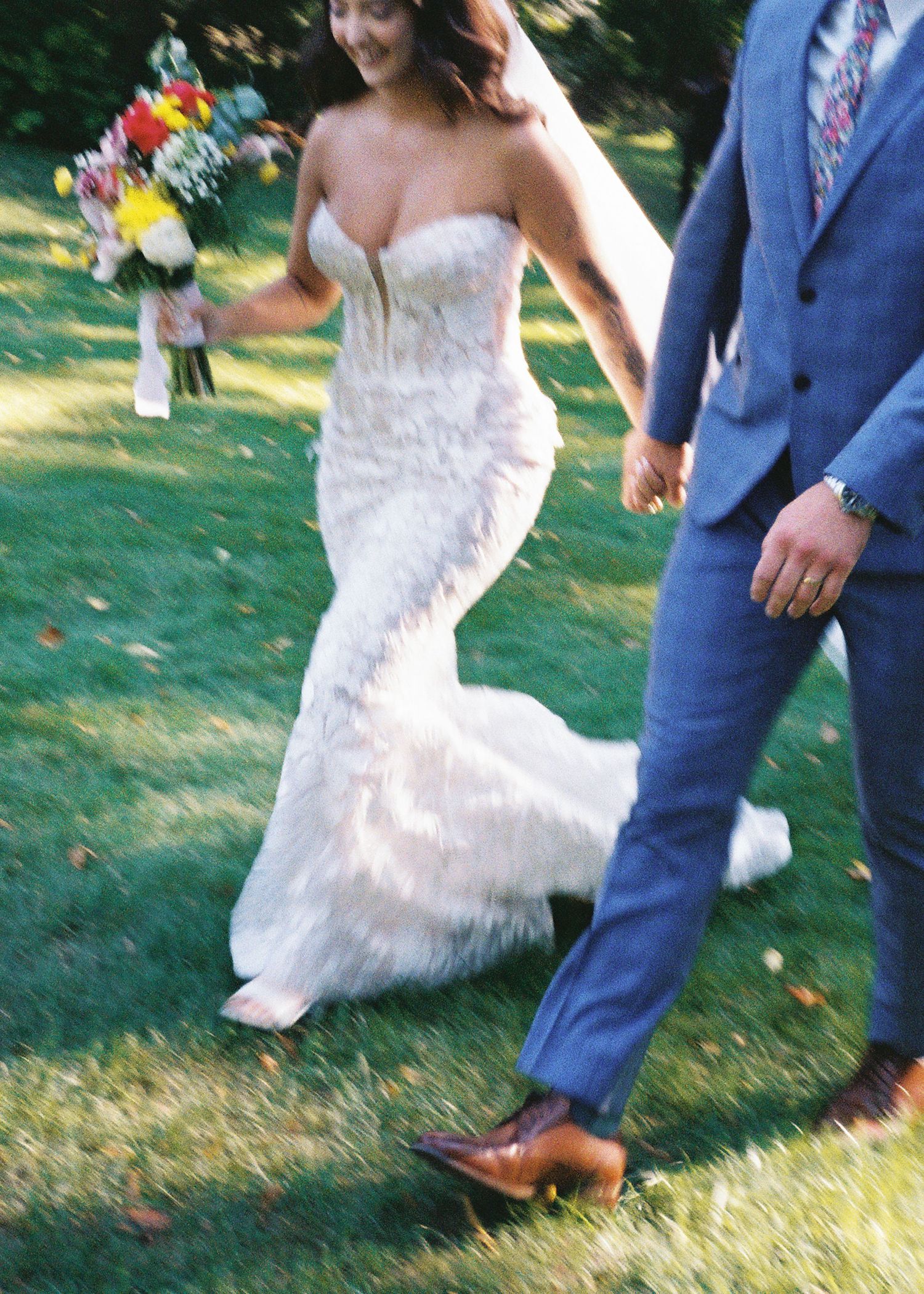 Close-up of dancing feet at a wedding, showing a white dress and blue suit.