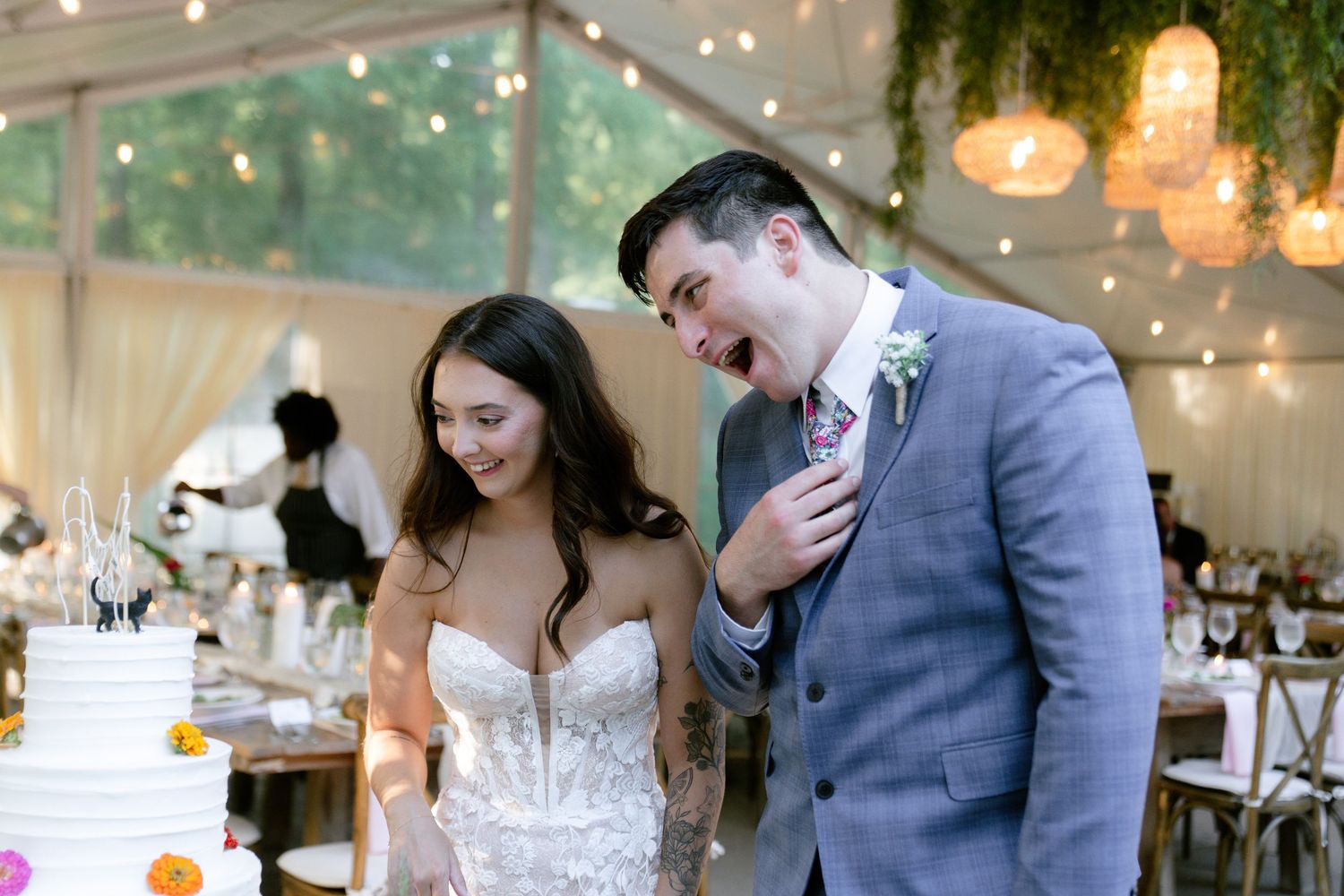 Wedding reception tent decorated with string lights and greenery creates romantic ambiance.