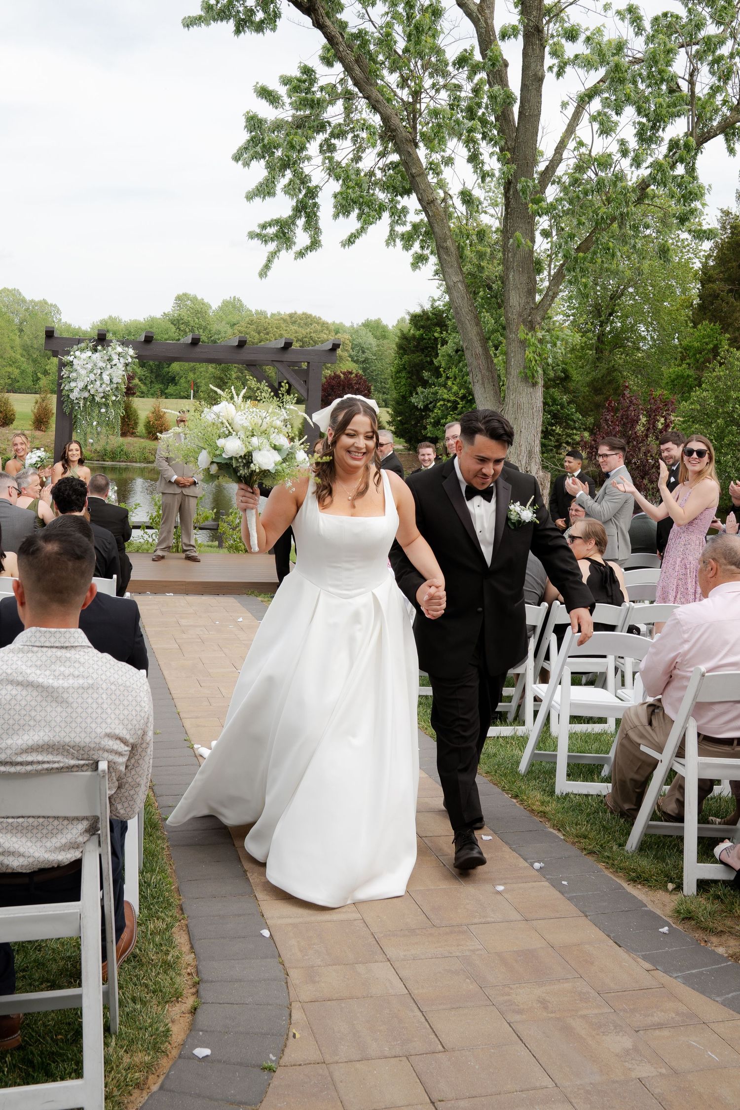 Wedding celebration on outdoor patio with guests in formal attire.