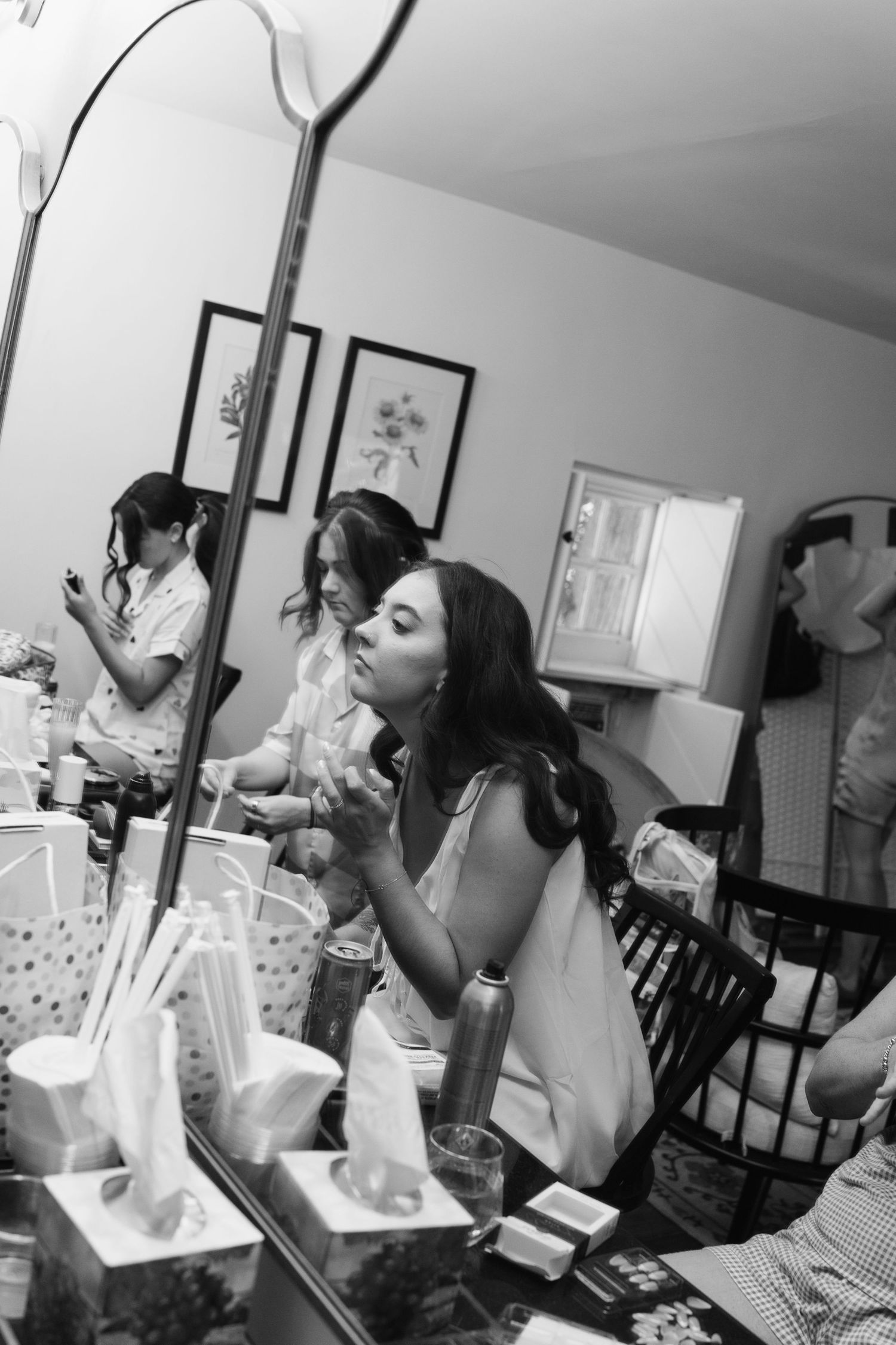 Black and white photo sequence of wedding day preparations at a vanity mirror.