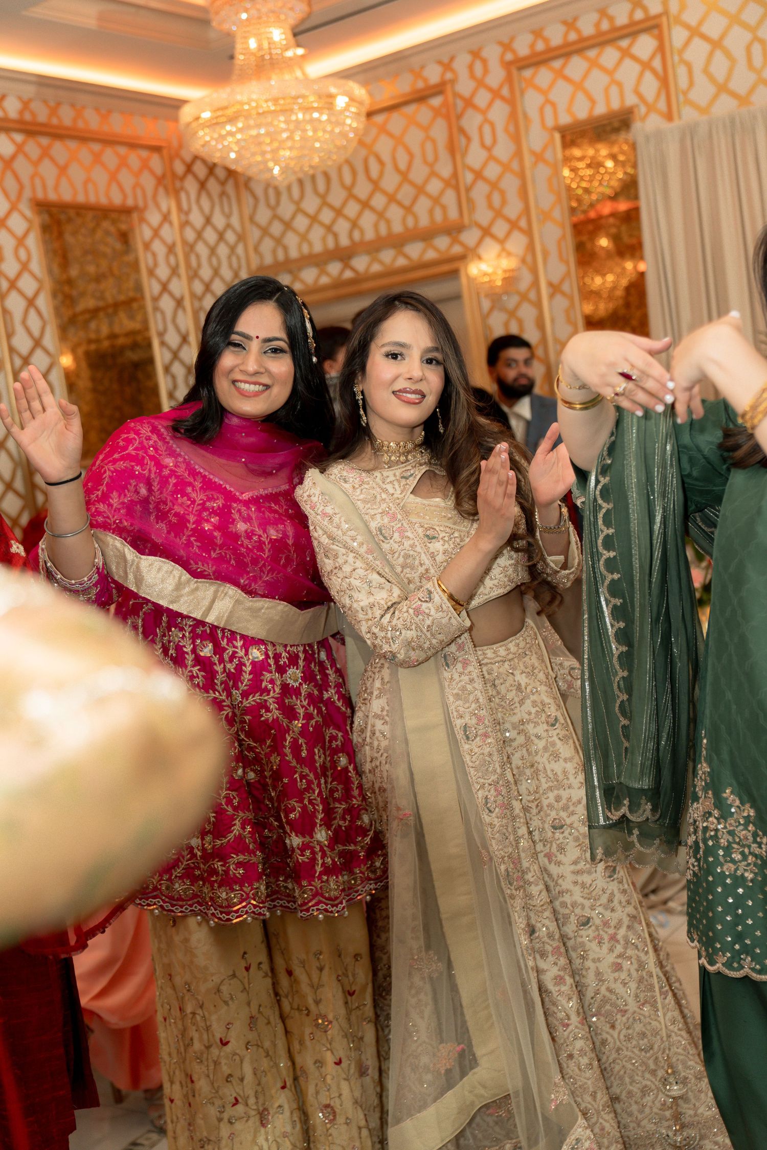 Guests in colorful traditional attire celebrate at an ornately decorated wedding reception.