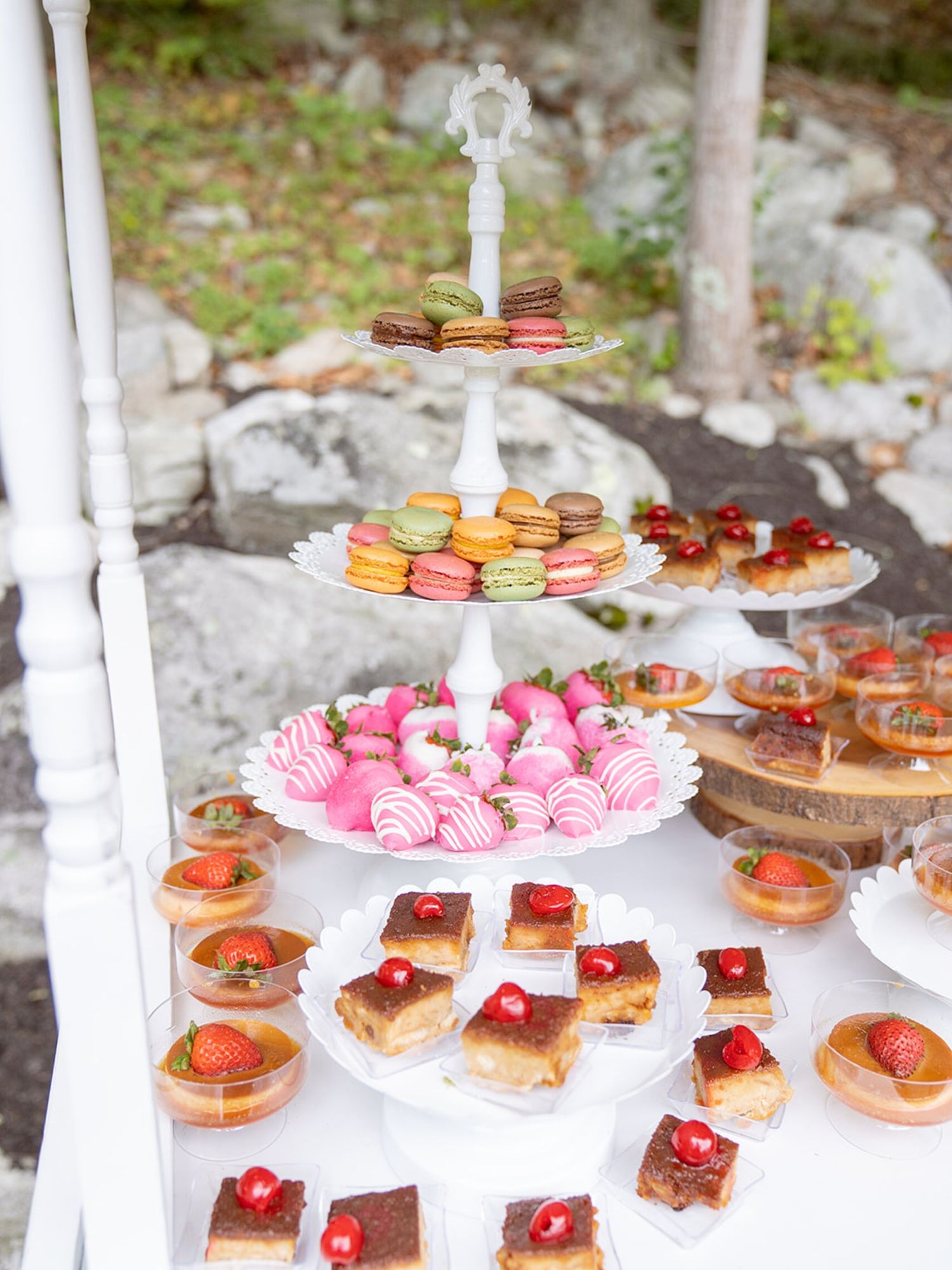 Elegant dessert display featuring colorful macarons and pastries on tiered white stands.
