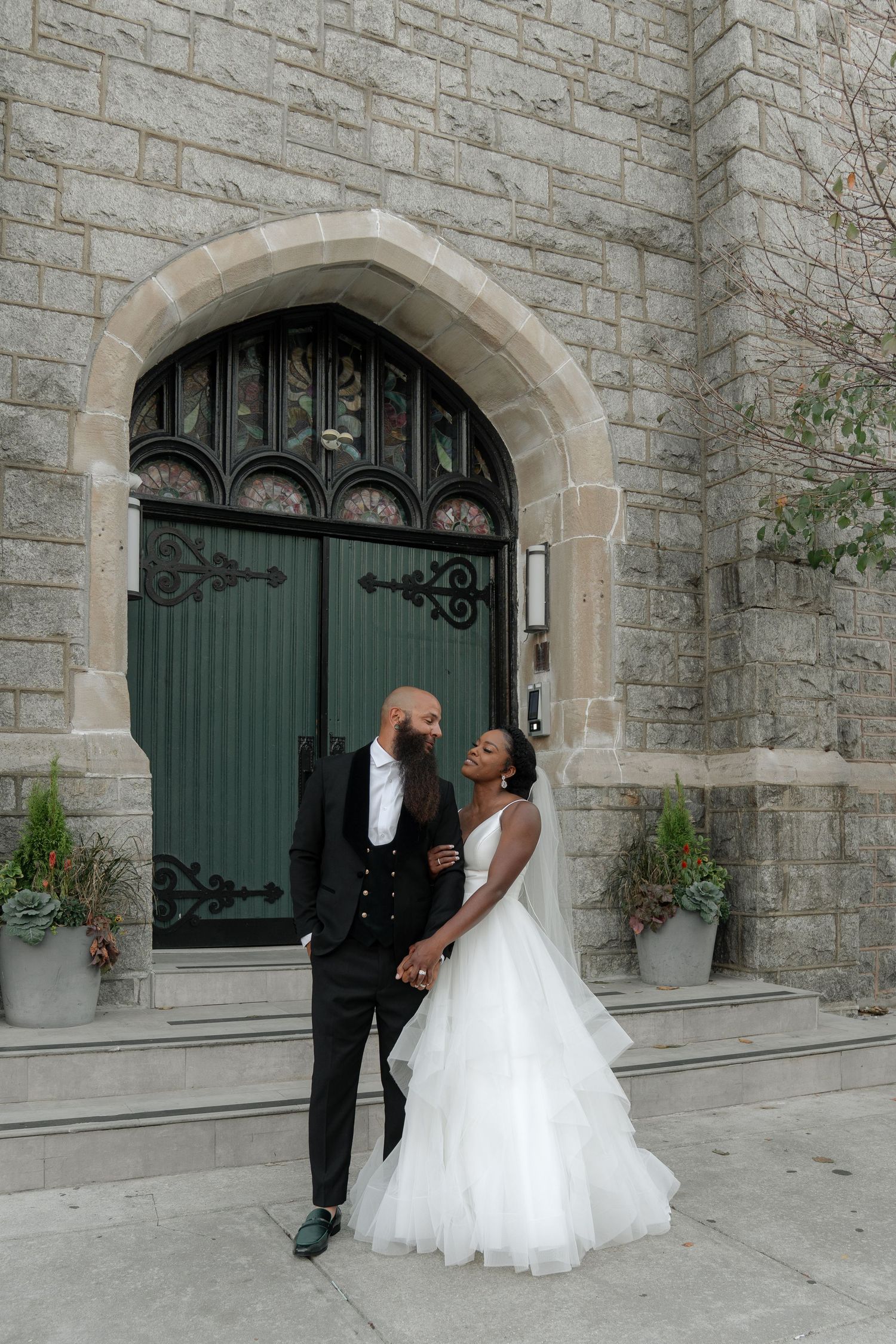 A series of candid wedding photos taken against a stone church facade with green doors.