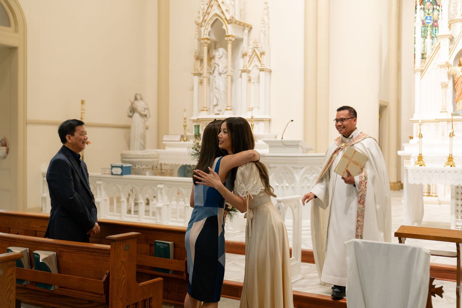 Wedding party gathered in a traditional church sanctuary with ornate altar and stained glass.