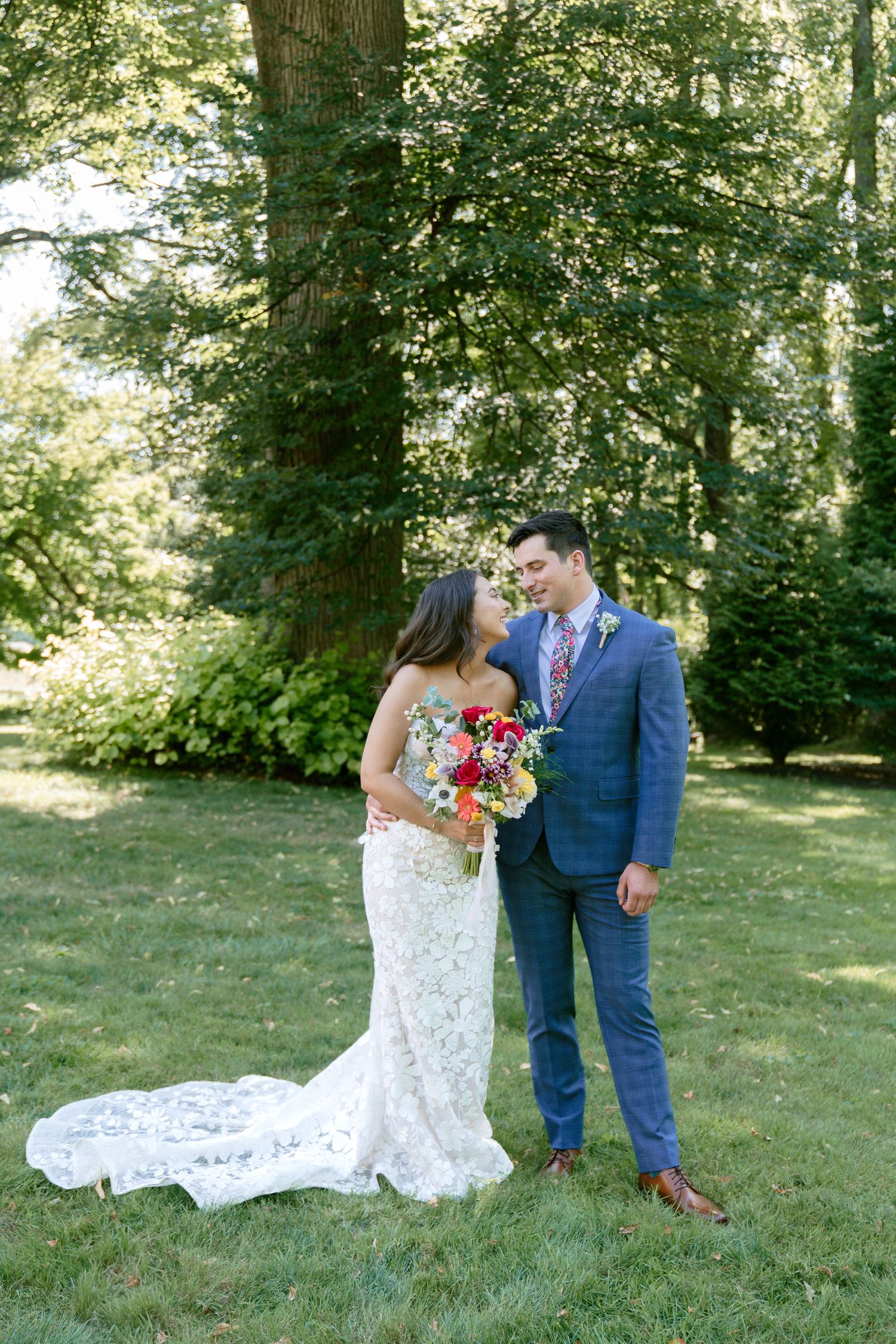 Newlywed couple poses for portraits in a scenic outdoor garden setting.