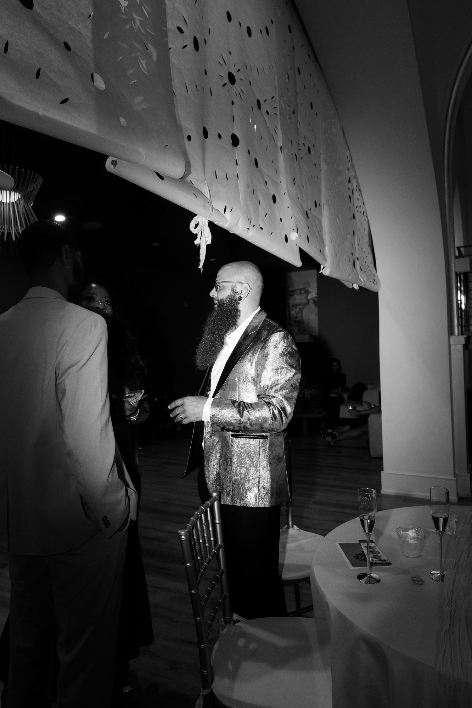 Black and white photos of people dancing and socializing at a dimly lit event.