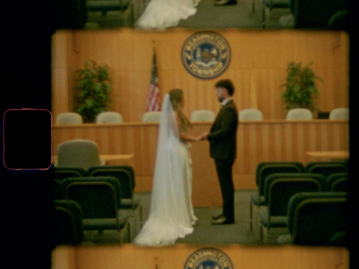 Bride and groom exchange vows holding hands in a formal courtroom civil wedding ceremony.