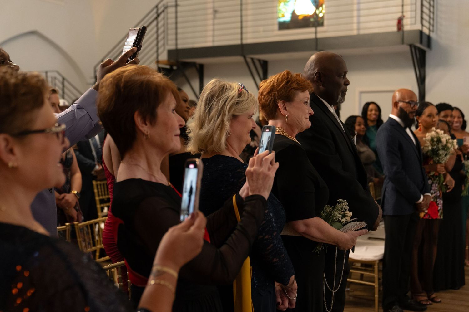 Wedding guests observe the ceremony from their seats in an intimate venue setting.