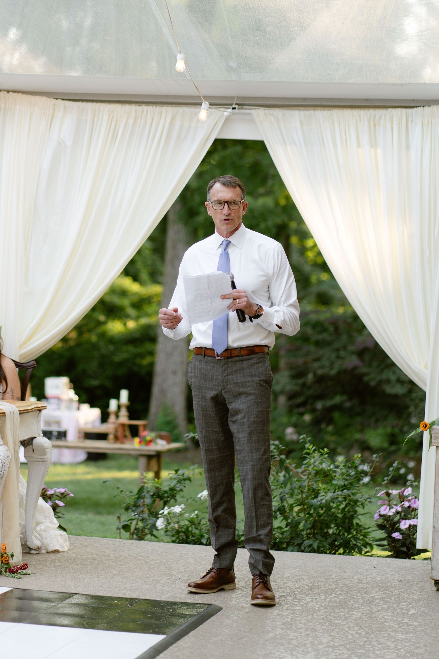White draped tent setup for an outdoor wedding reception.