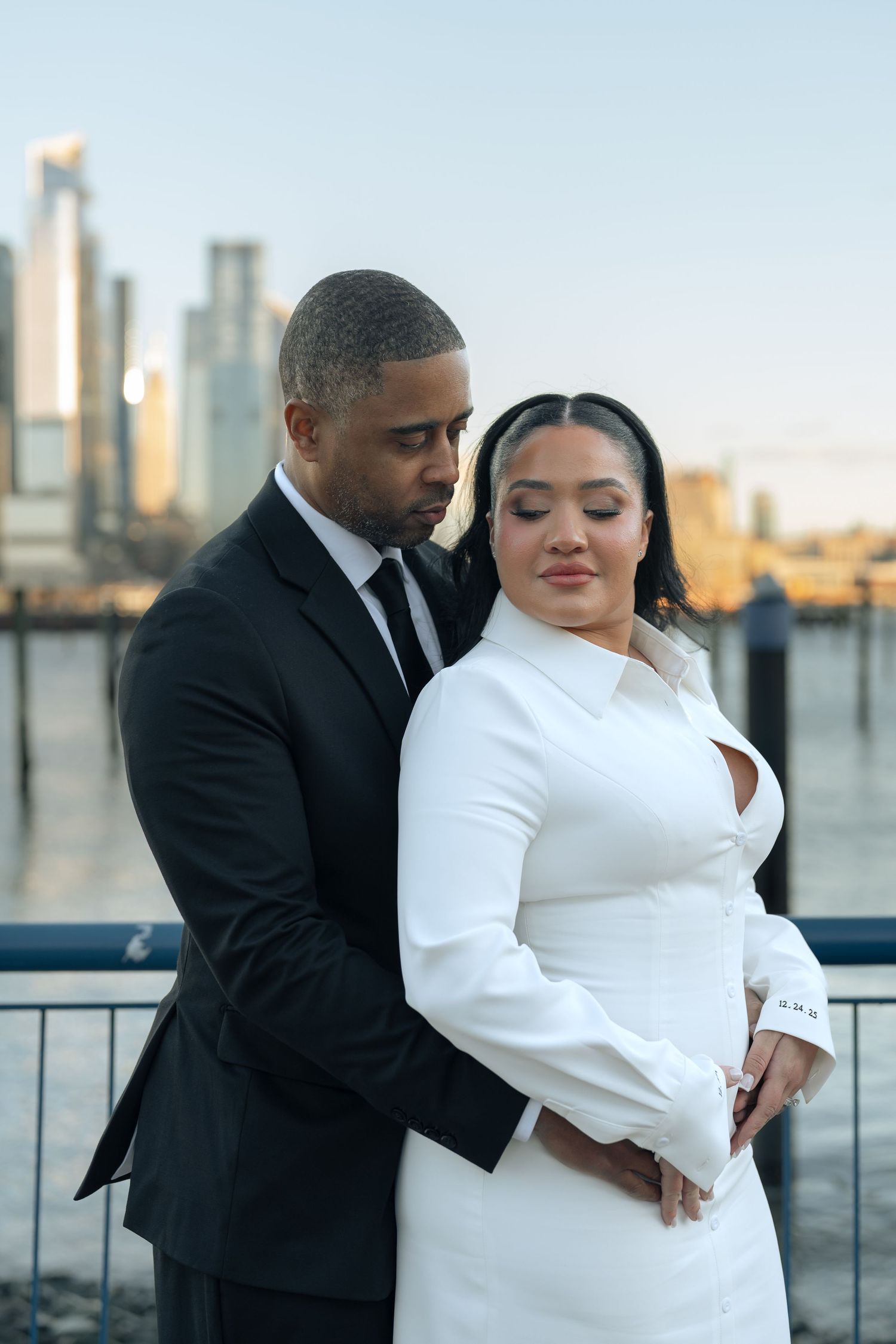 Wedding couple sharing intimate moments with city skyline in background.