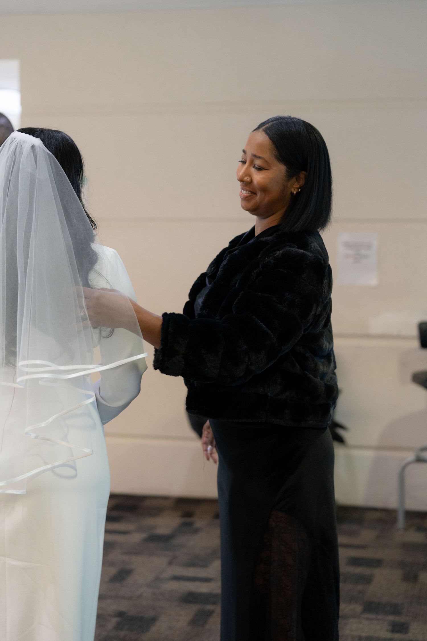 A sequence showing someone adjusting a flowing white veil against a light colored wall.