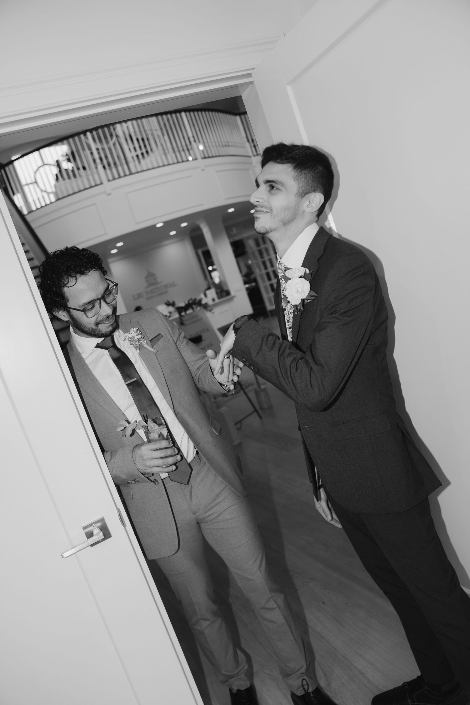 A series of black and white photos showing people in suits talking in an office hallway.