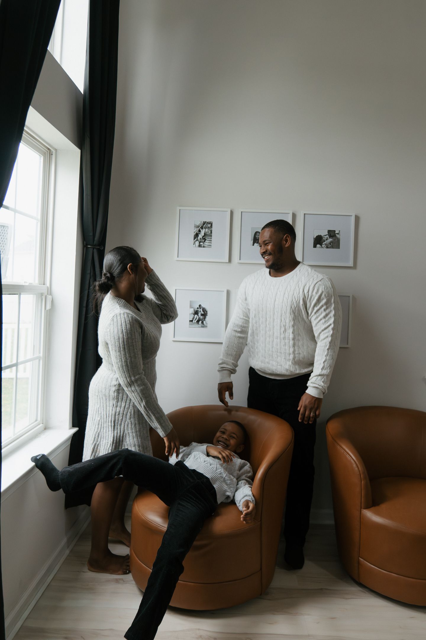 A sequence of playful interactions on a brown leather couch near a window with framed artwork.