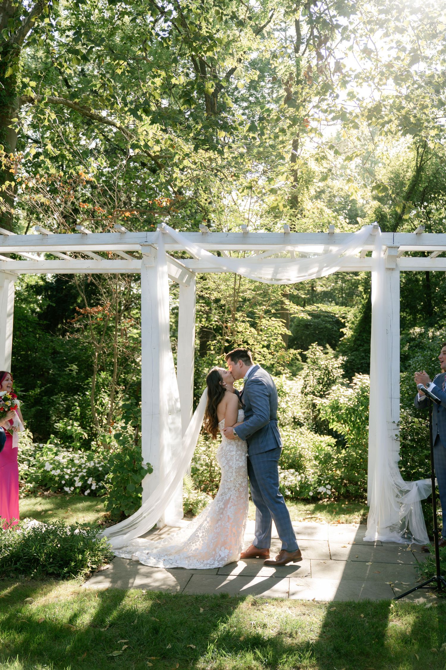 Wedding ceremony sequence under a white pergola with flowing fabric decorations.