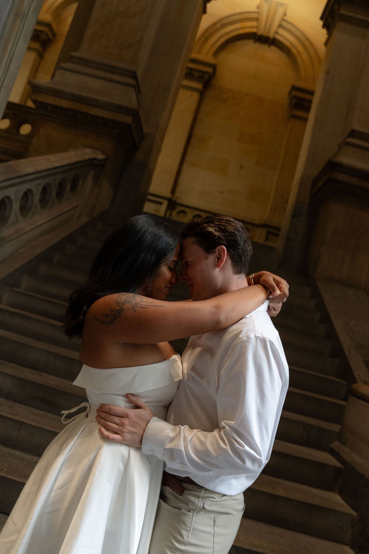 Intimate couple sharing a romantic moment in an ornate historic building interior.