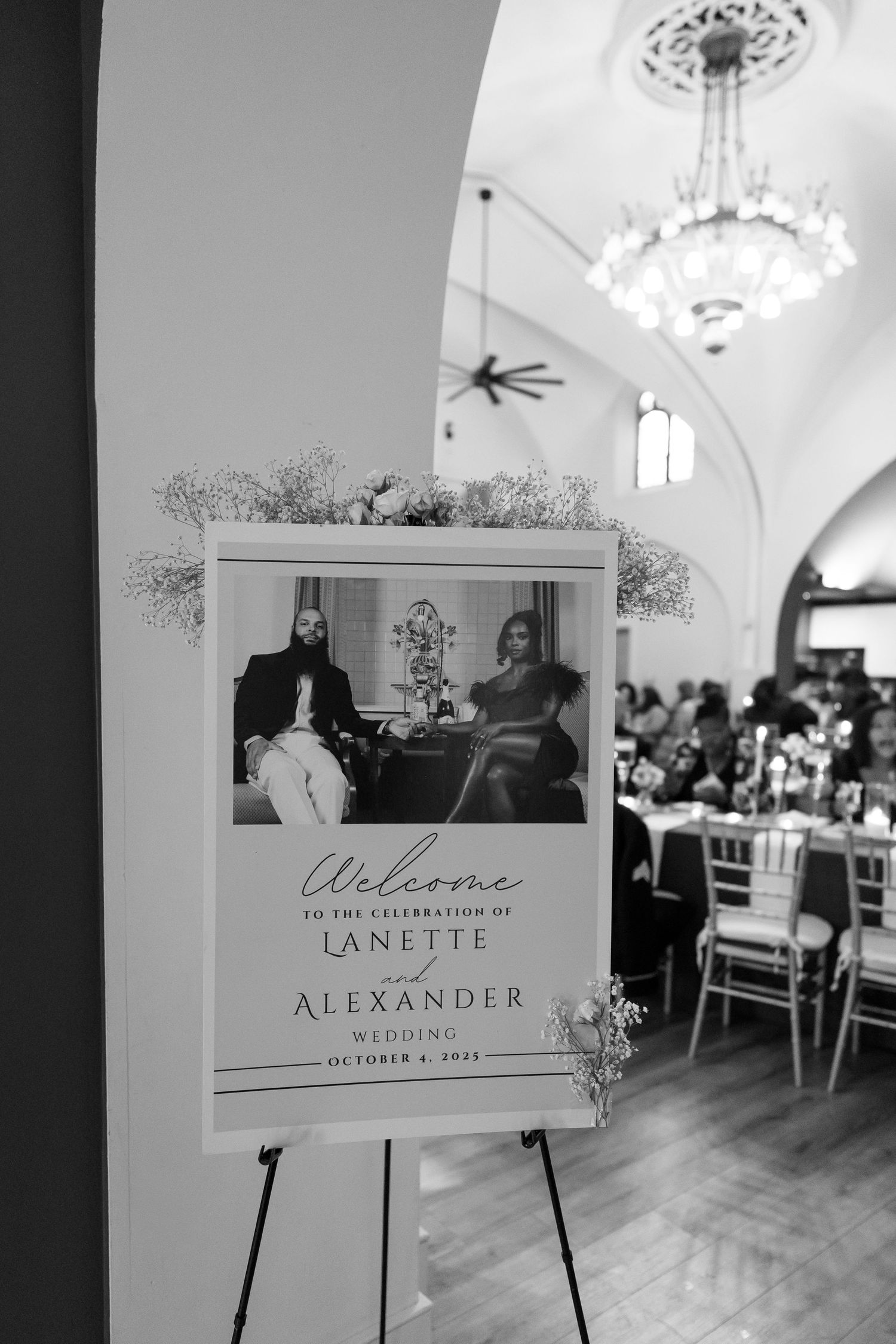 Elegant wedding venue signage and welcome displays in black and white with decorative floral accents.