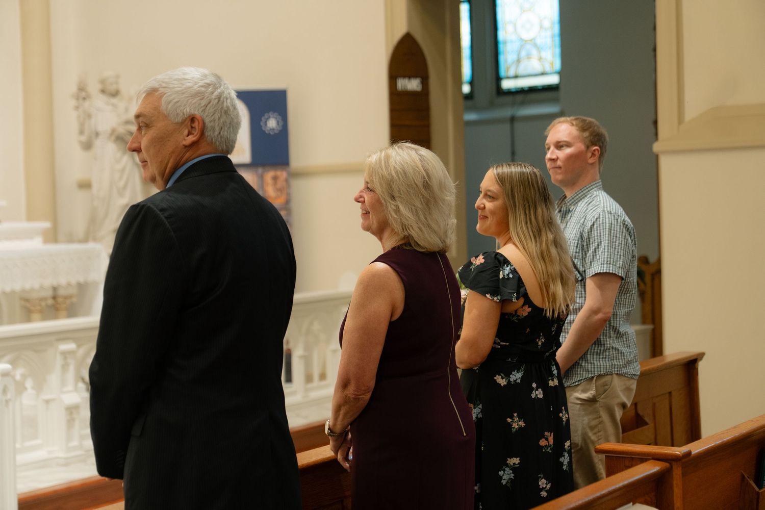 Wedding guests mingling in a church gathering space after the ceremony.