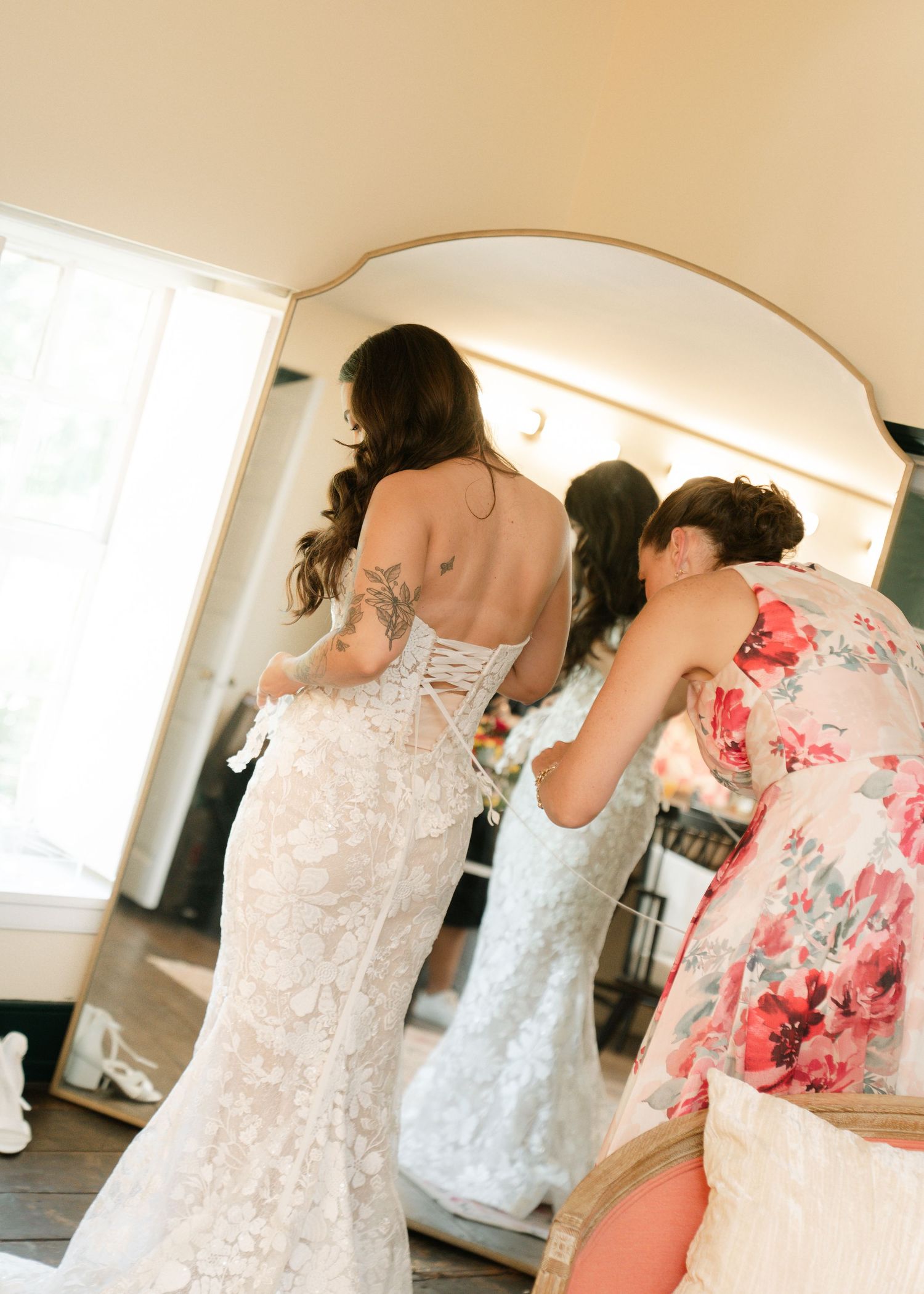 A group tries on elegant white lace wedding dresses in a bridal boutique fitting room.