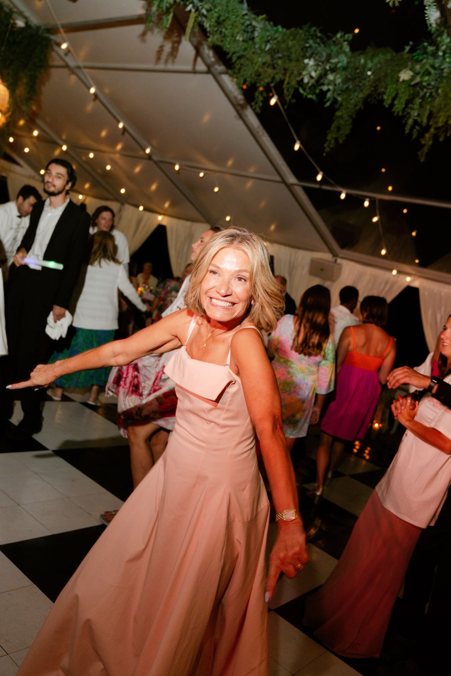 Wedding guests enjoying themselves on the dance floor during an evening reception.
