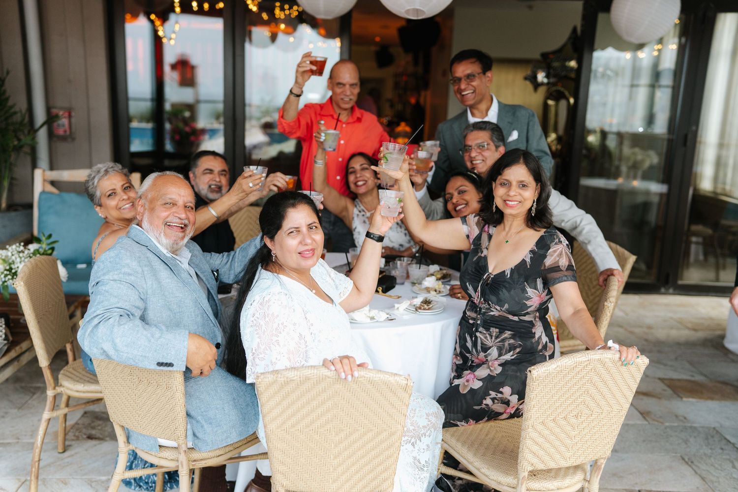 Casual outdoor gathering with guests seated at tables enjoying conversation and refreshments.