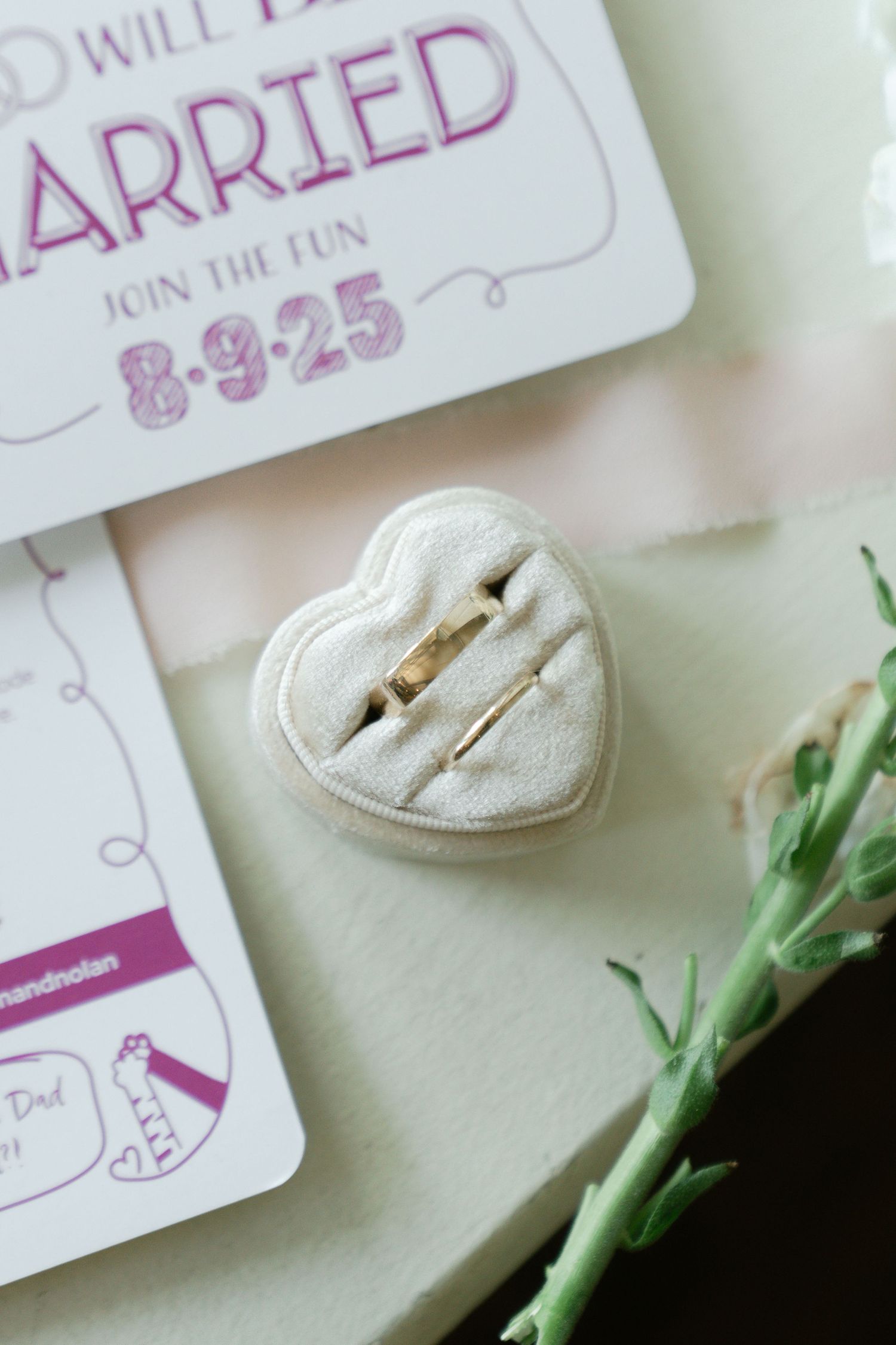 Wedding details including handwritten cards and delicate floral elements arranged on a light surface.