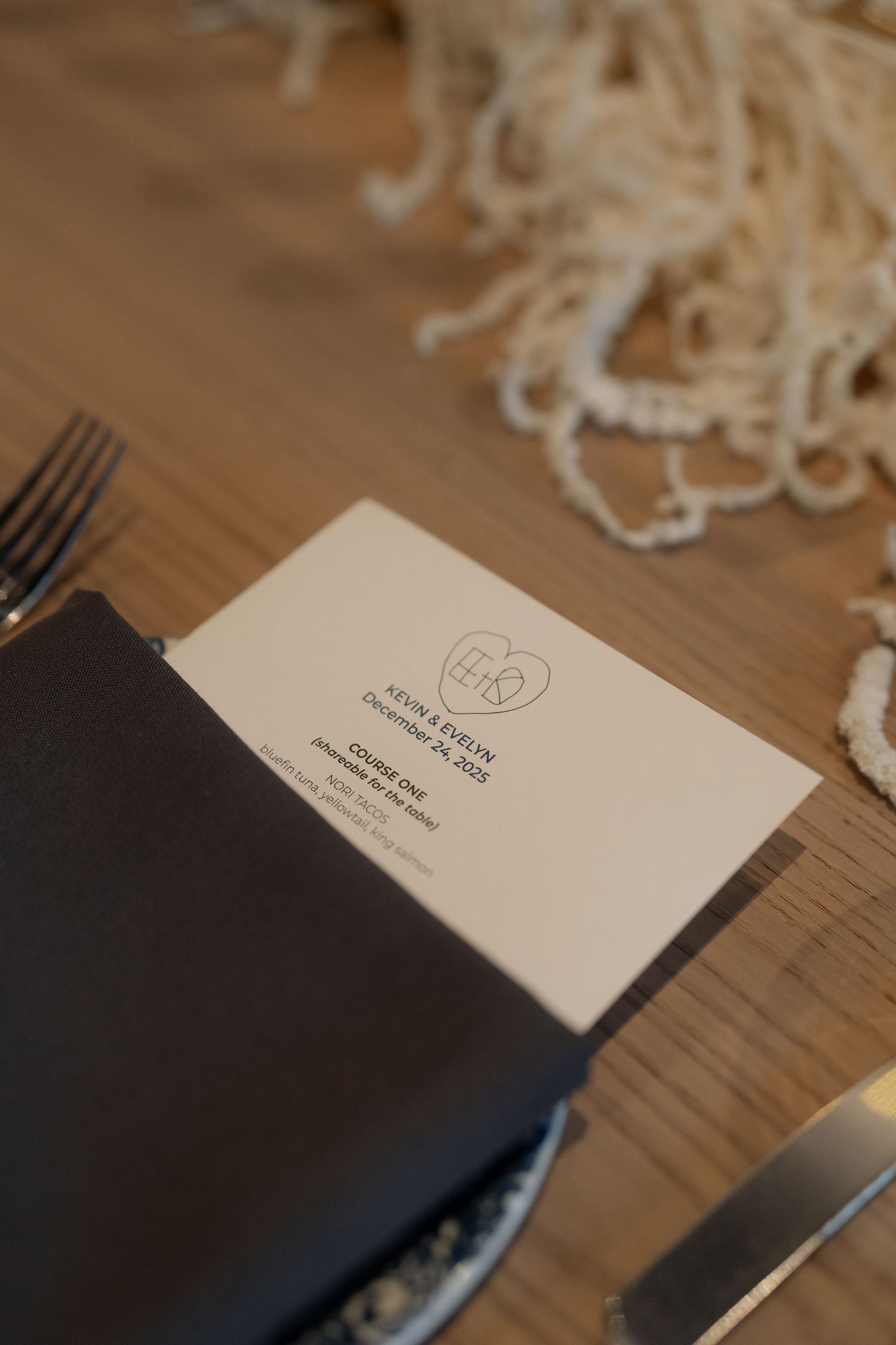 Business cards and paper materials arranged on a wooden surface with soft lighting.