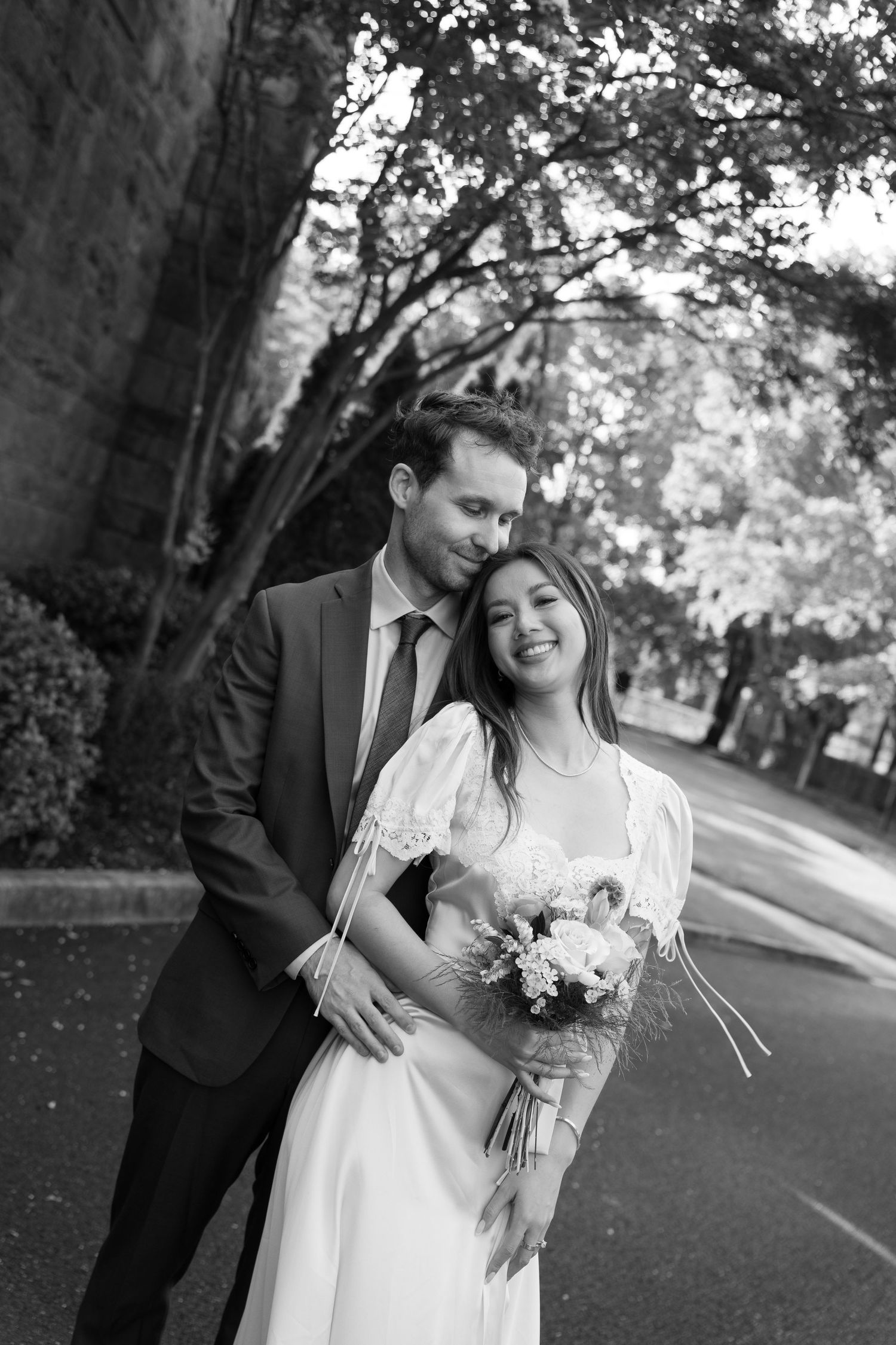 Romantic outdoor wedding portraits captured on a tree-lined street.
