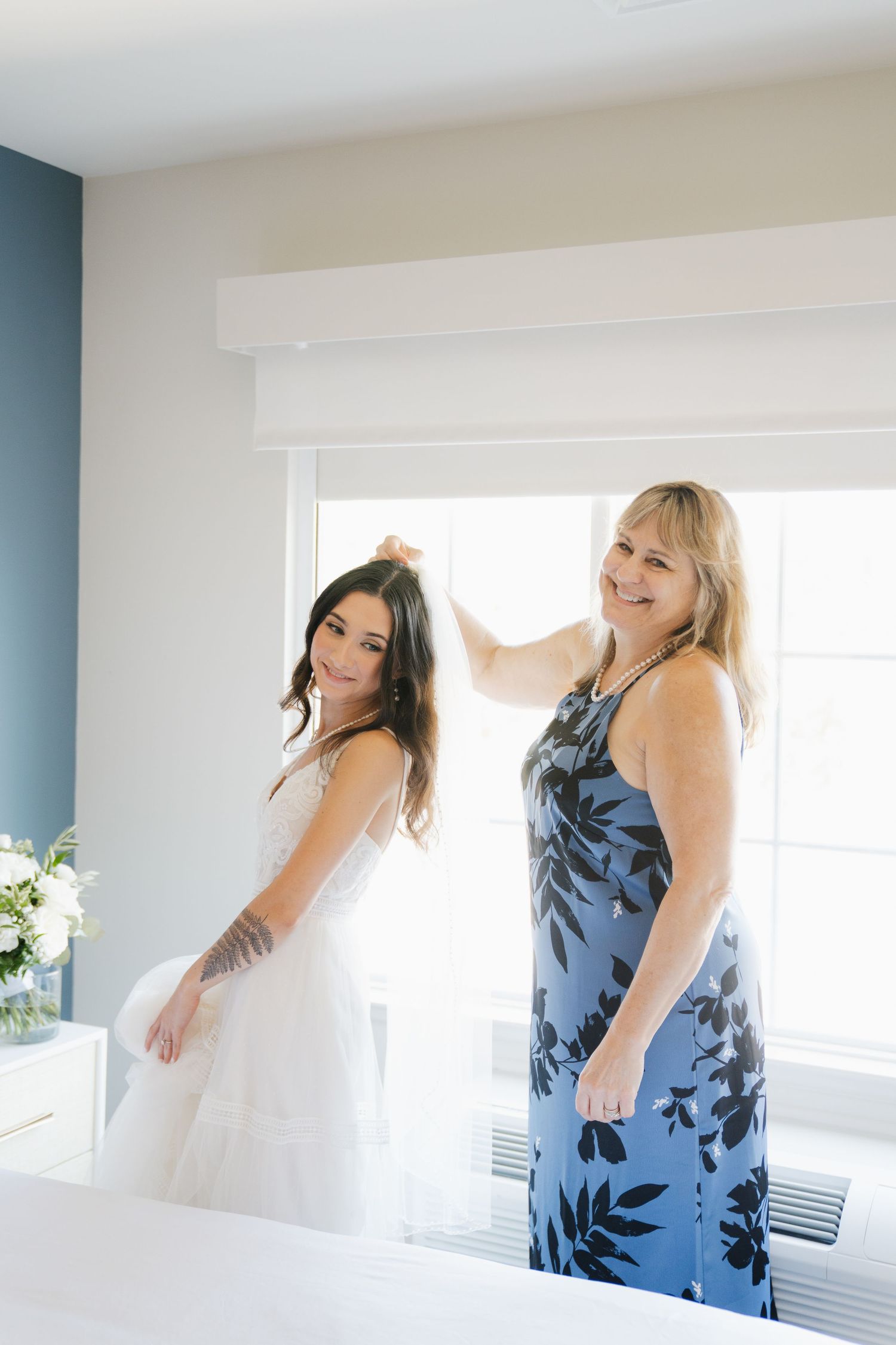 A series of photos showing people in blue floral dresses and white gowns dancing joyfully by a window.