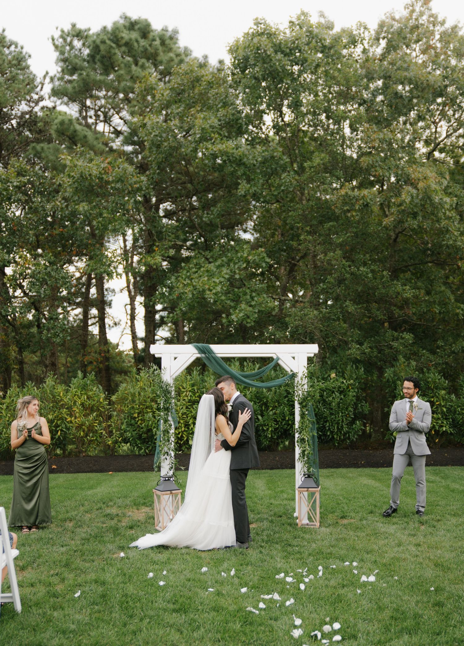 A romantic outdoor wedding ceremony sequence showing the couple exchanging vows under a floral arch in a lush green garden.