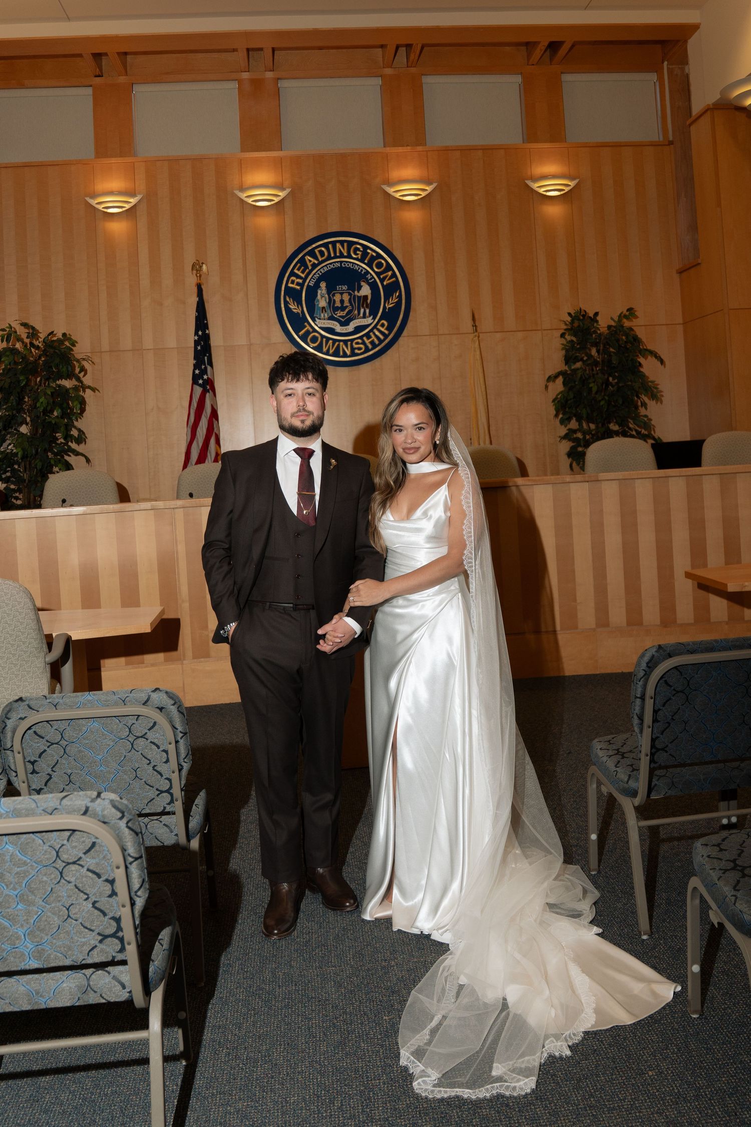 Bride and groom posing together inside Readington Township courthouse after civil ceremony.