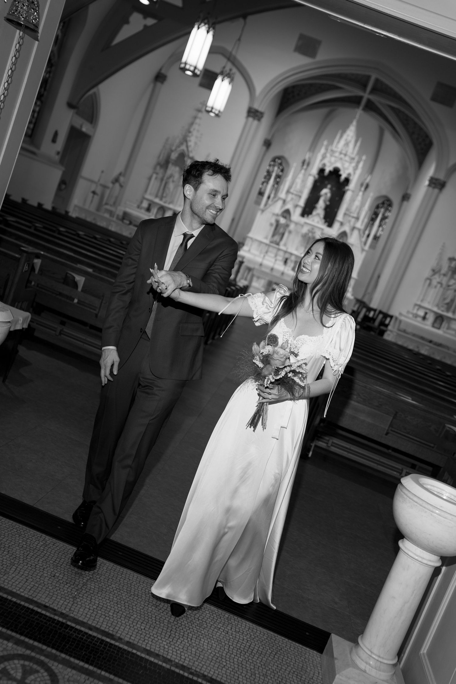 Black and white photos of intimate church wedding ceremony with Gothic architectural details.
