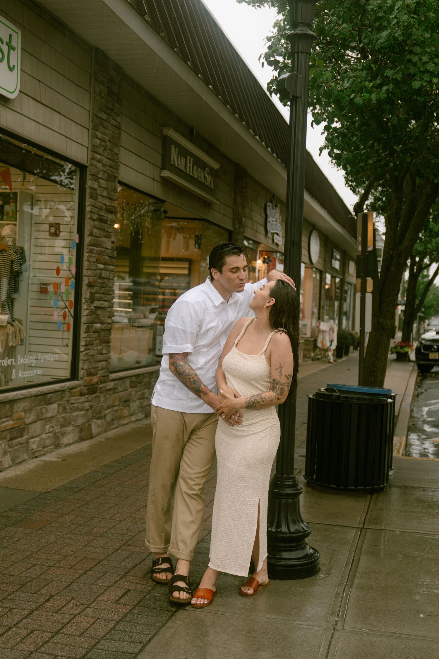 Couple sharing affectionate moments on a charming brick-lined street.