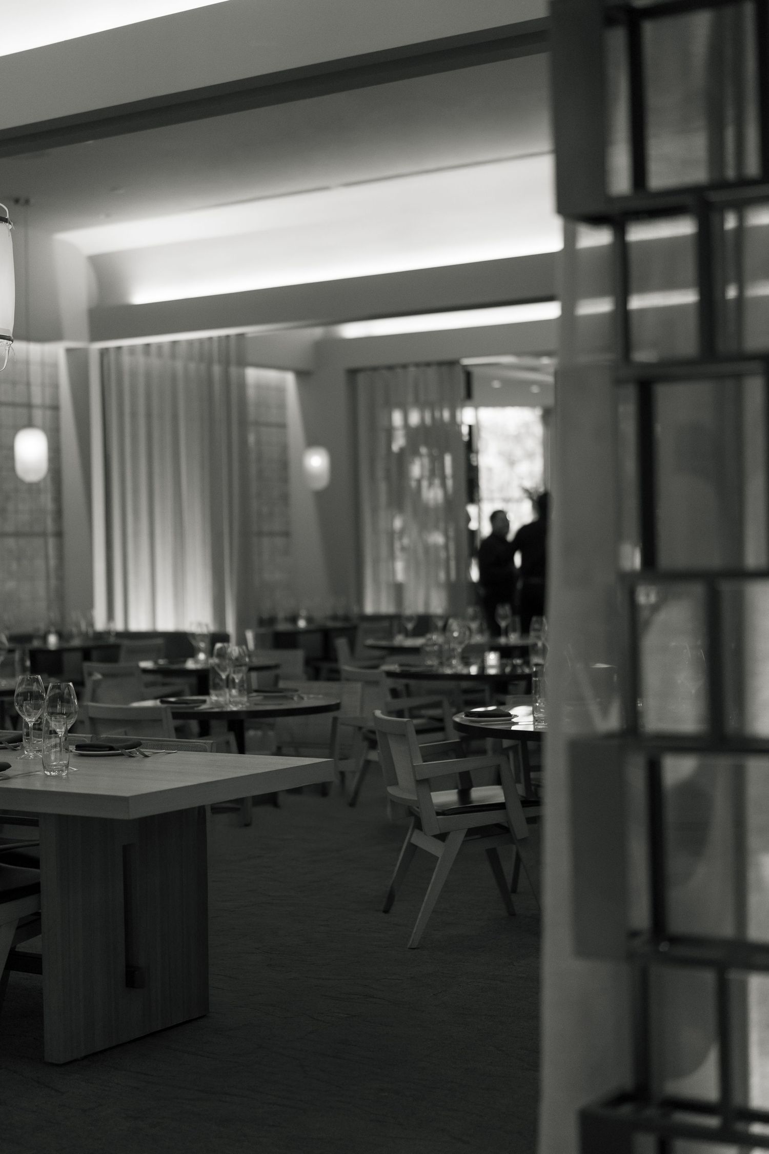 Interior view of an empty modern dining room with tables and chairs.