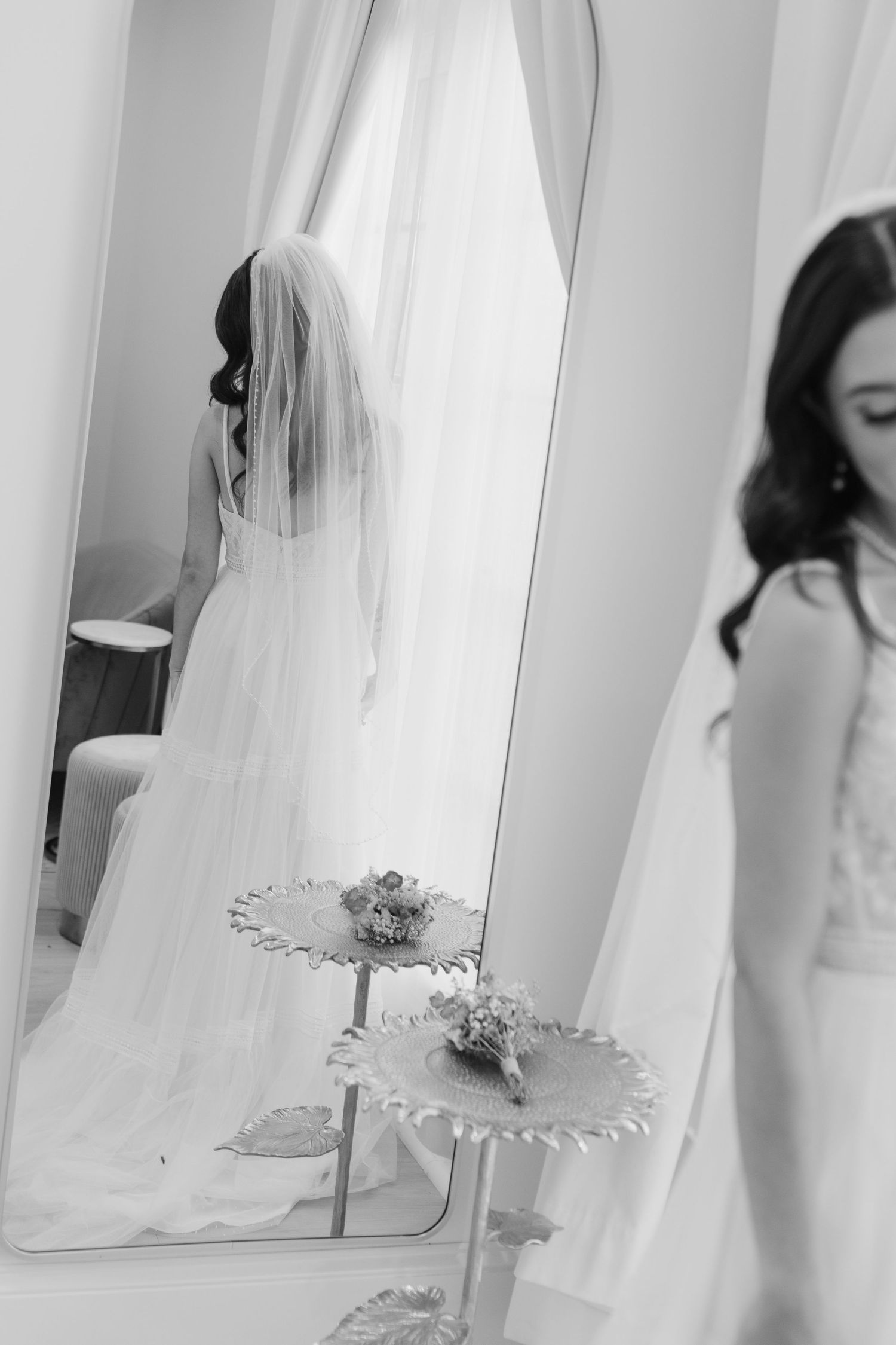 A series of black and white bridal photos showing wedding dresses and veils in a mirror reflection.